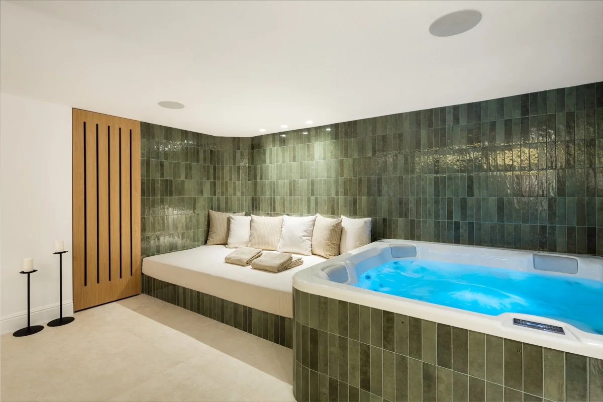 Indoor wellness area featuring a built-in heated jacuzzi and mosaic tile walls.