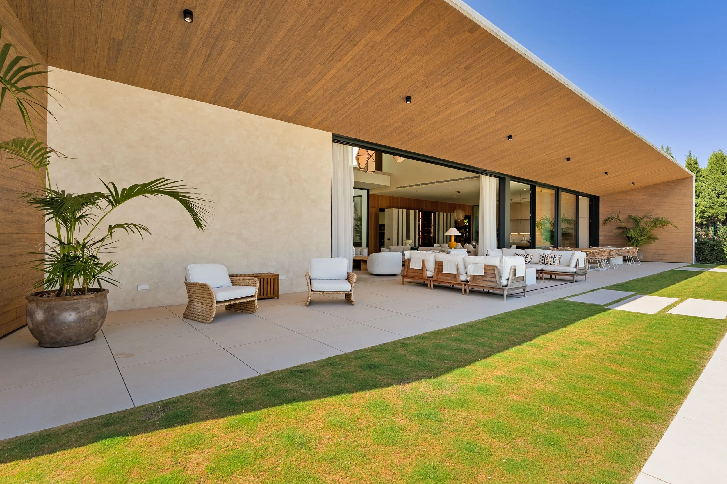 Large covered terrace featuring a lounge area that transitions seamlessly into the open-plan living room.