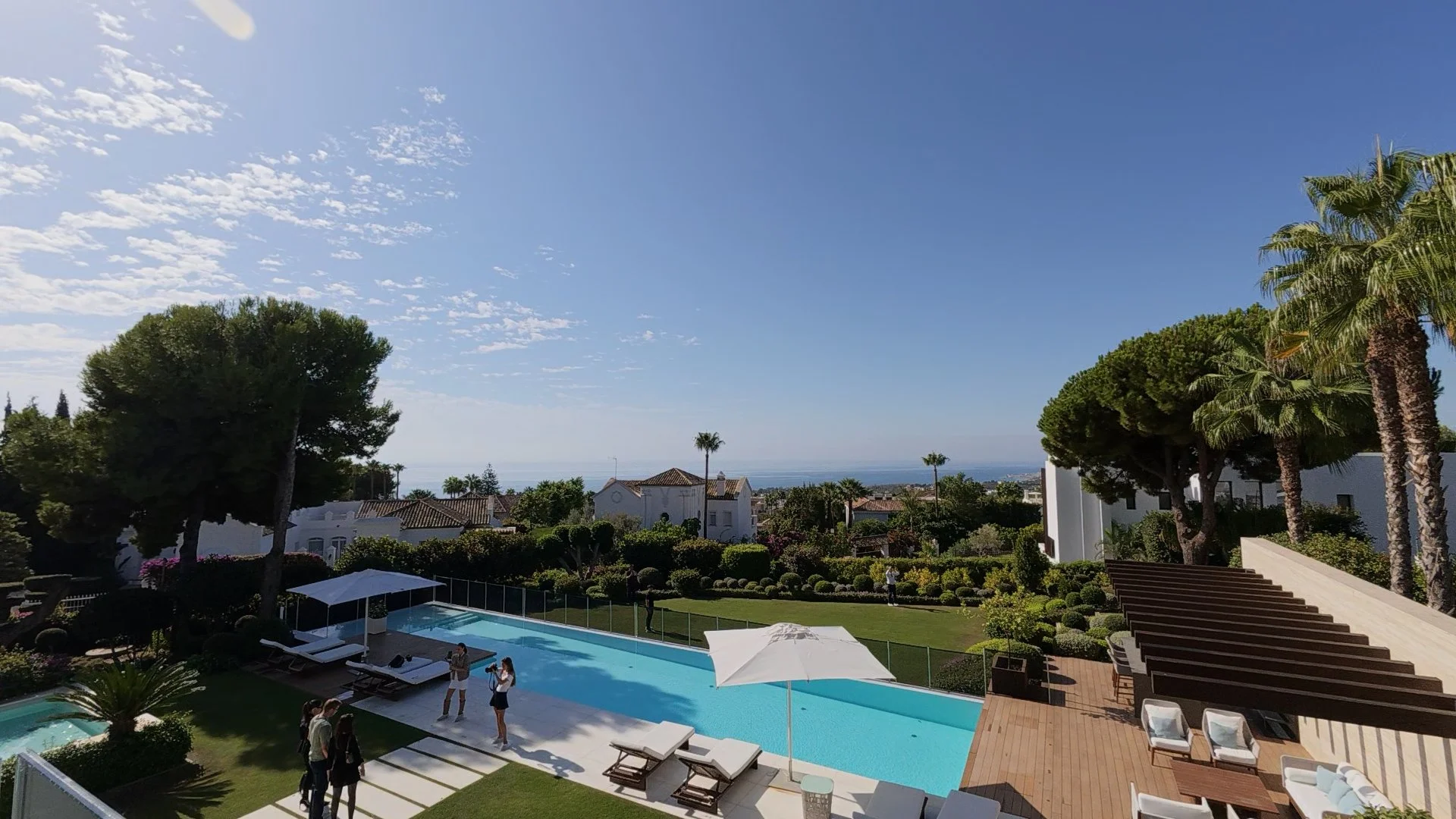 Elevated perspective from the digital tour showing the expansive infinity pool area and sun deck overlooking the Mediterranean sea horizon from Sierra Blanca.