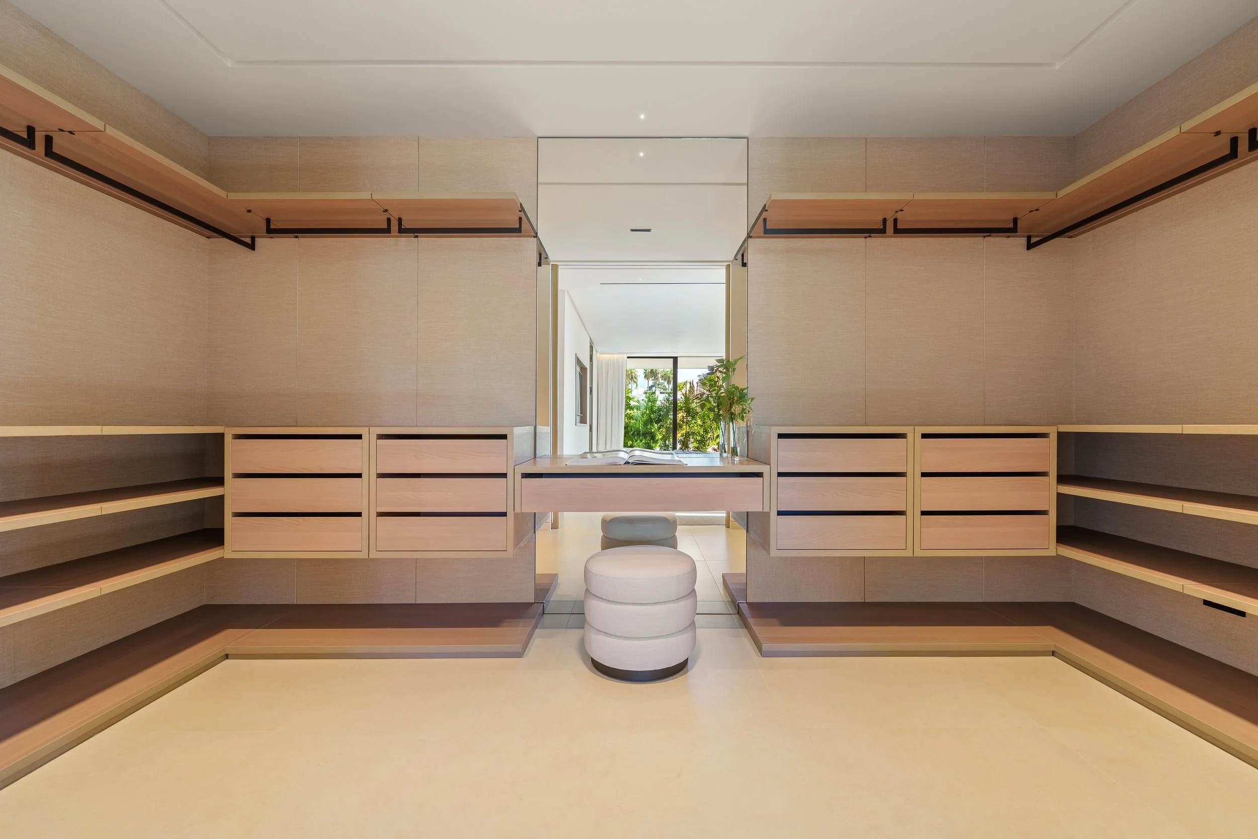 Large master walk-in closet with custom light-wood cabinetry and integrated LED lighting.