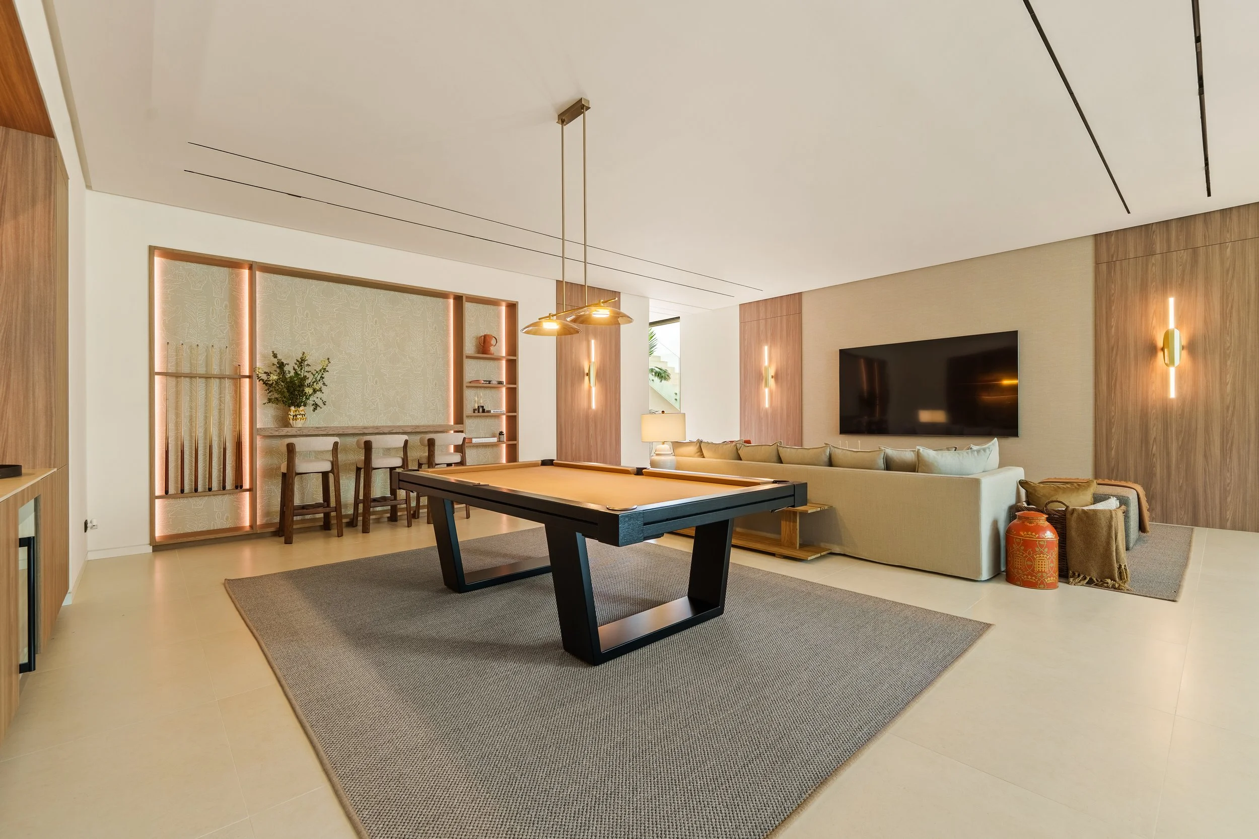 Spacious lower-level social room featuring a professional pool table and a comfortable lounge area.