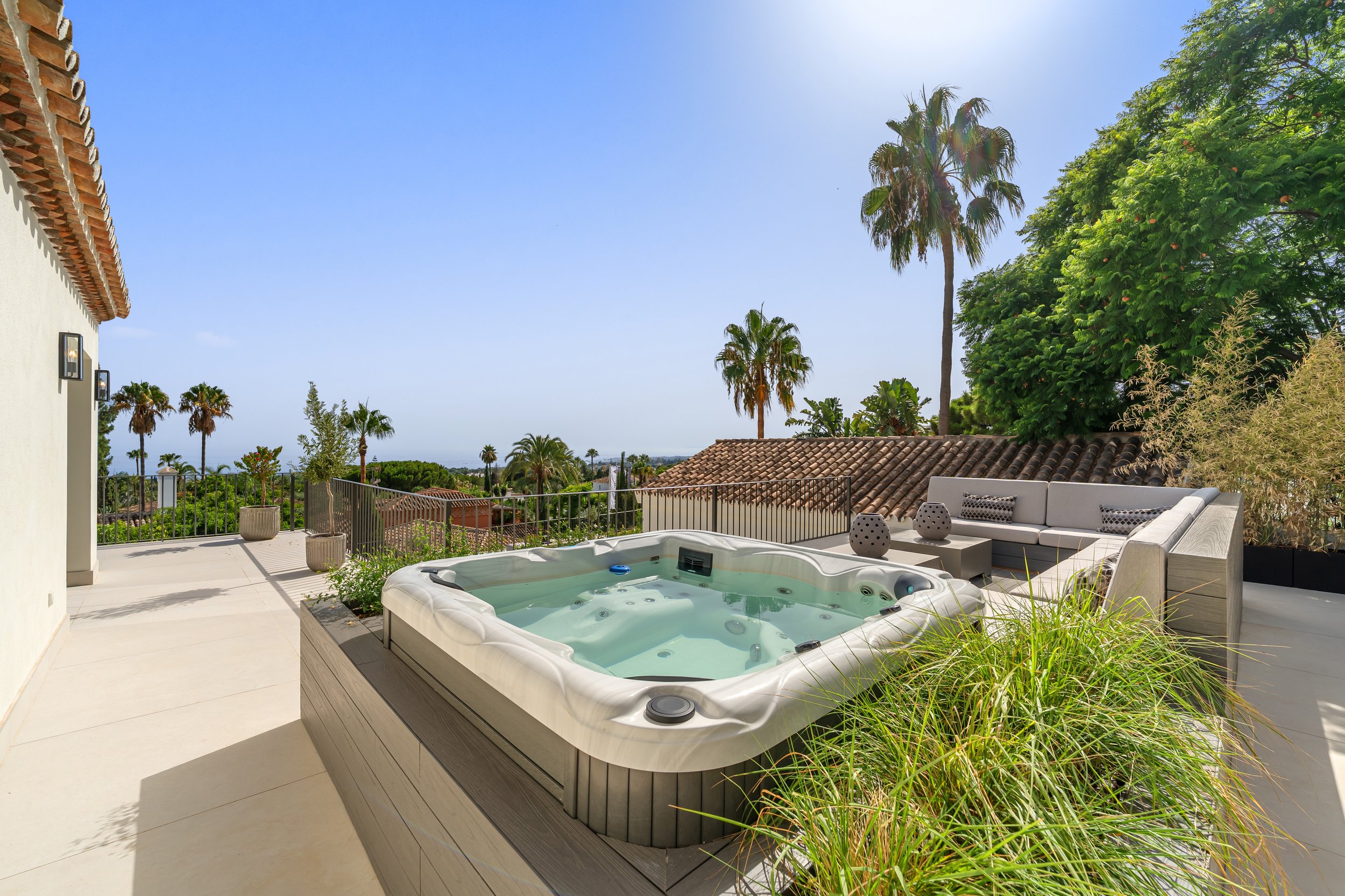 Luxury rooftop terrace featuring a private jacuzzi and lounge area with panoramic views of the Marbella coastline.