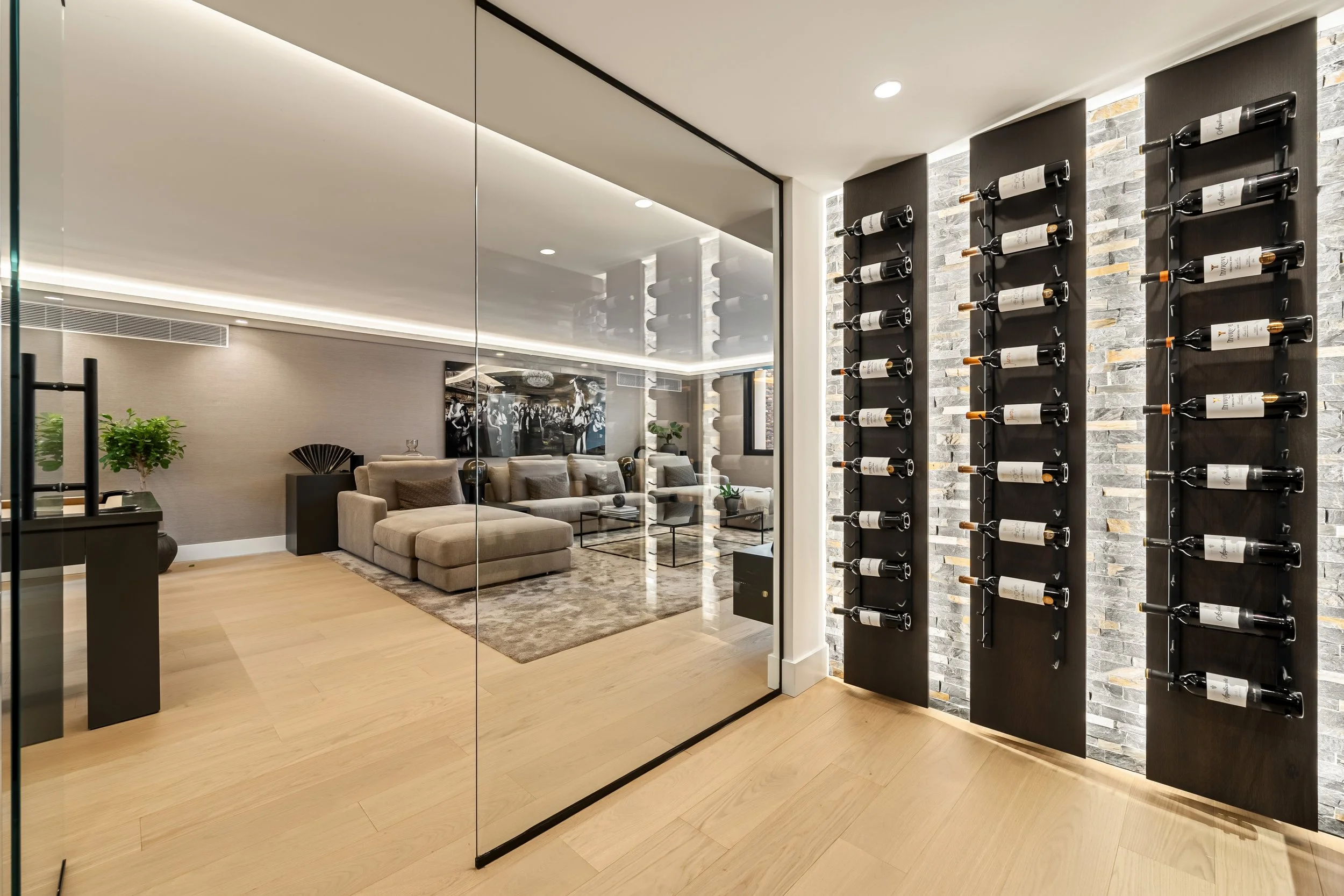 State-of-the-art glass-fronted wine cellar with custom vertical bottle racking and atmospheric lighting.
