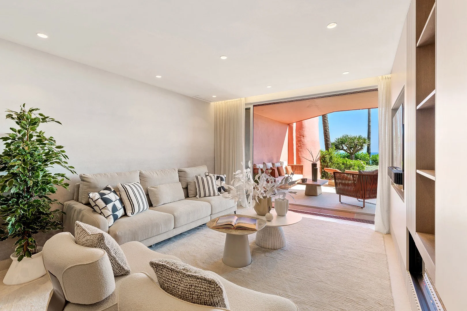 Designer open-plan living room with warm lighting, bespoke cabinetry, and contemporary furniture.