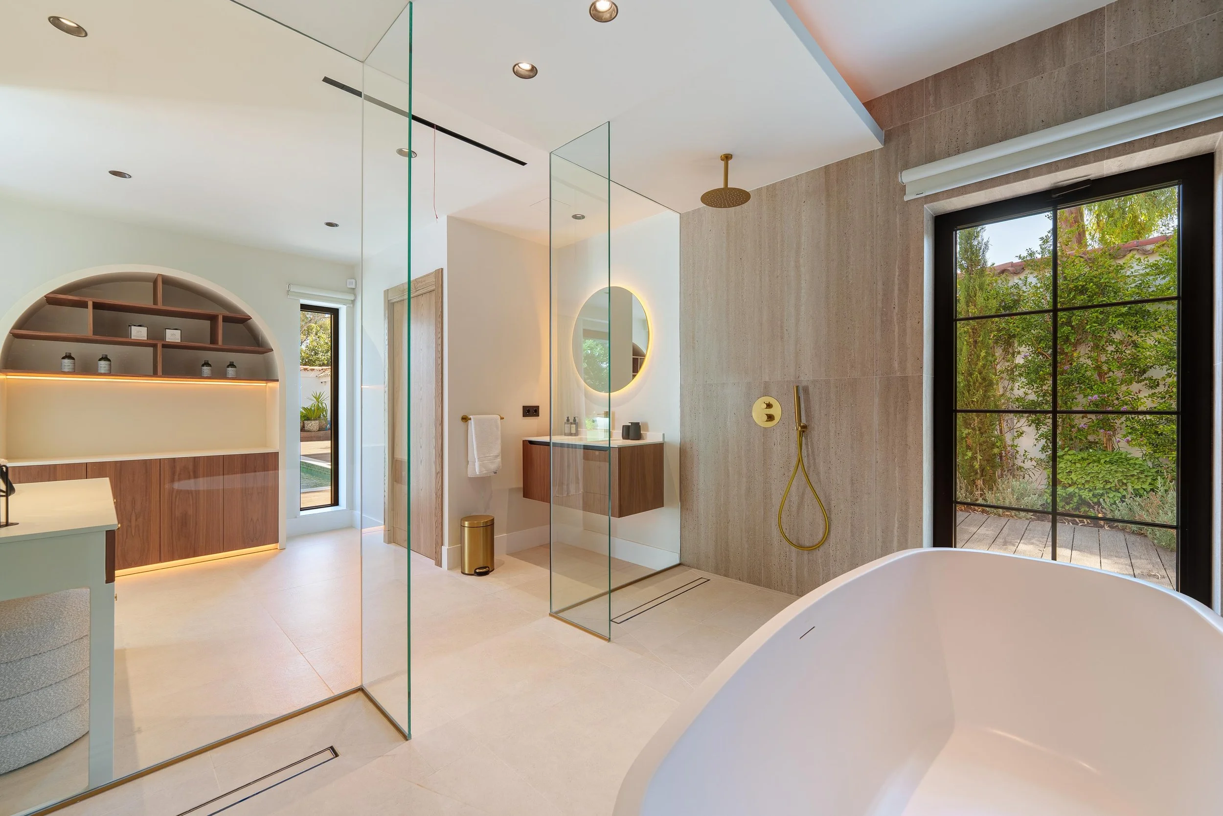 Modern en-suite bathroom featuring a freestanding soaking tub and walk-in rain shower.
