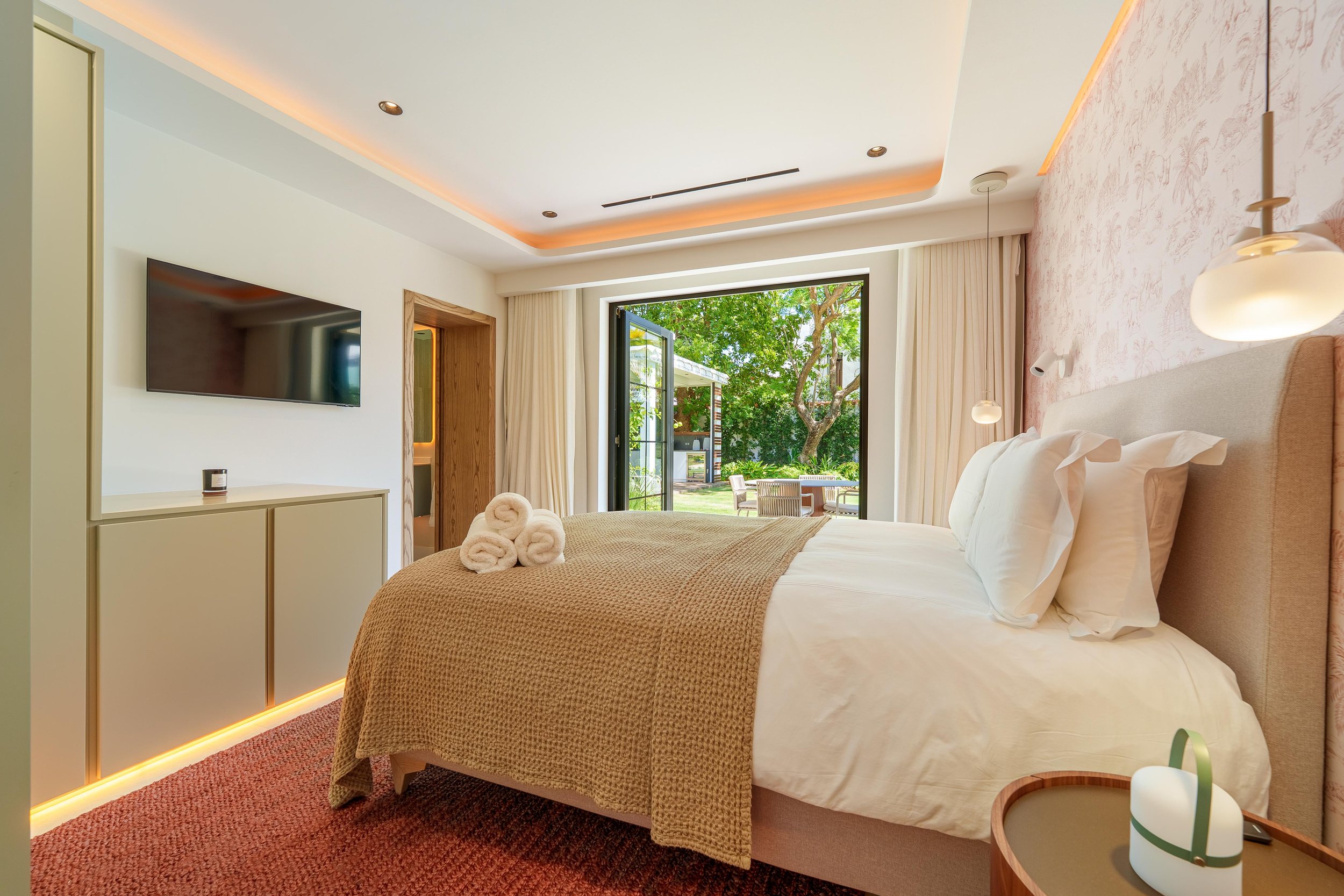 Spacious primary bedroom suite with direct access to the pool terrace.  Primary Bathroom: Showcasing the freestanding tub.