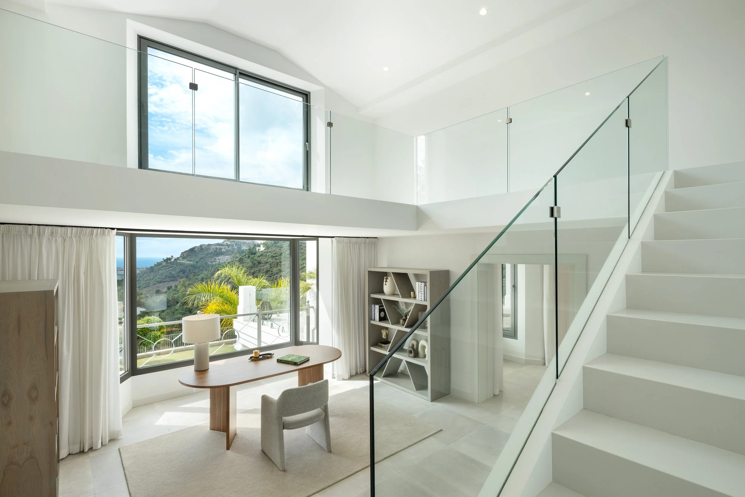 A bright, modern office or library space located on the main floor with direct views of the surrounding nature