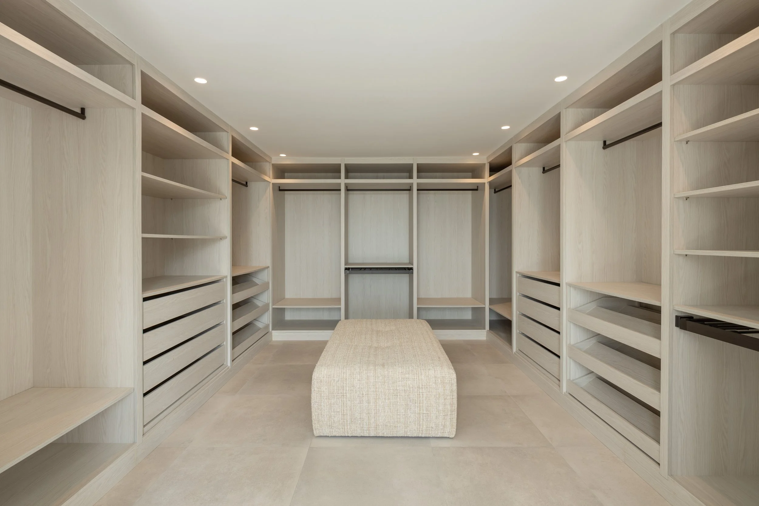 An expansive, custom-built walk-in dressing room with extensive storage and a central island.