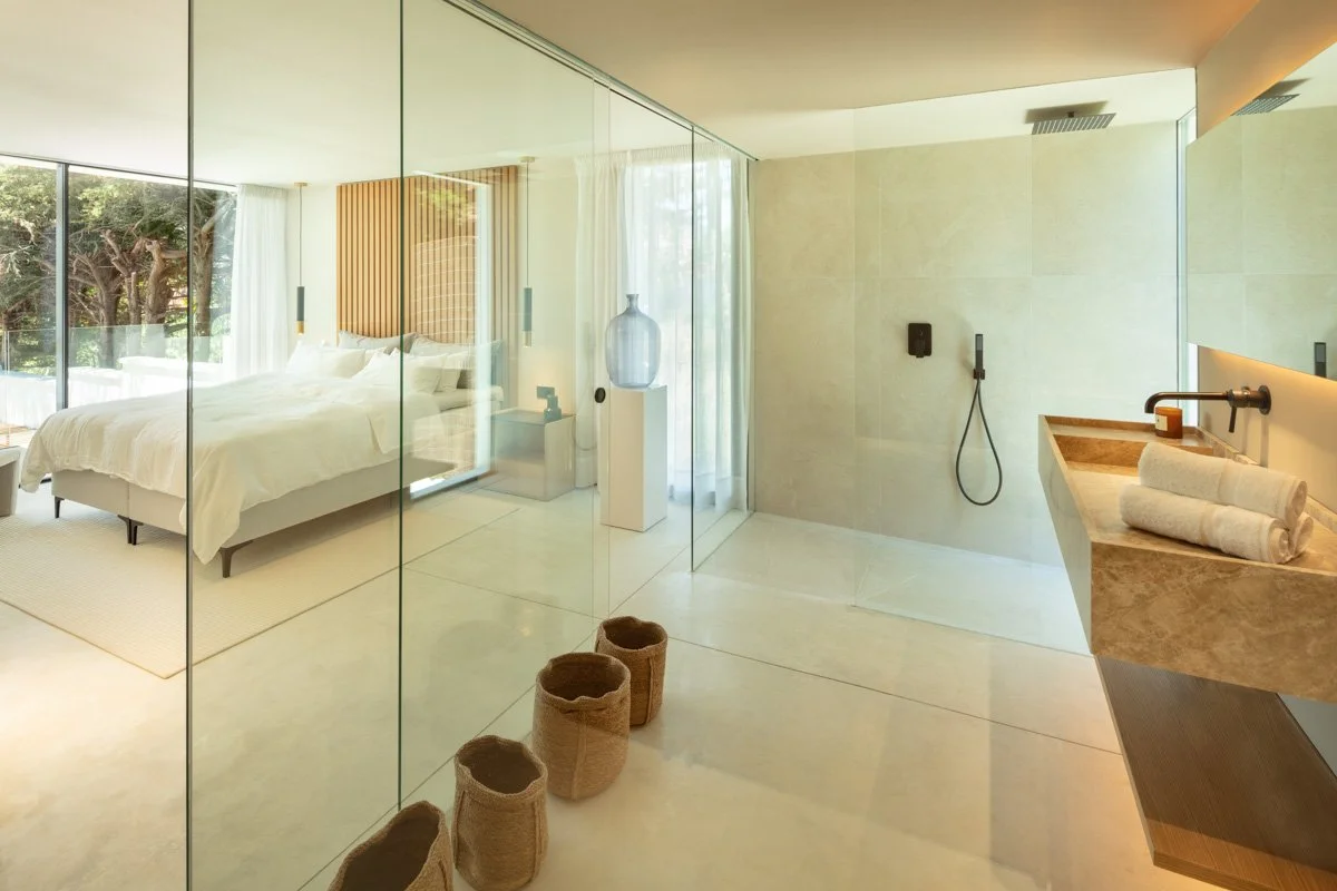Luxury ensuite with a freestanding stone bathtub and private garden views.