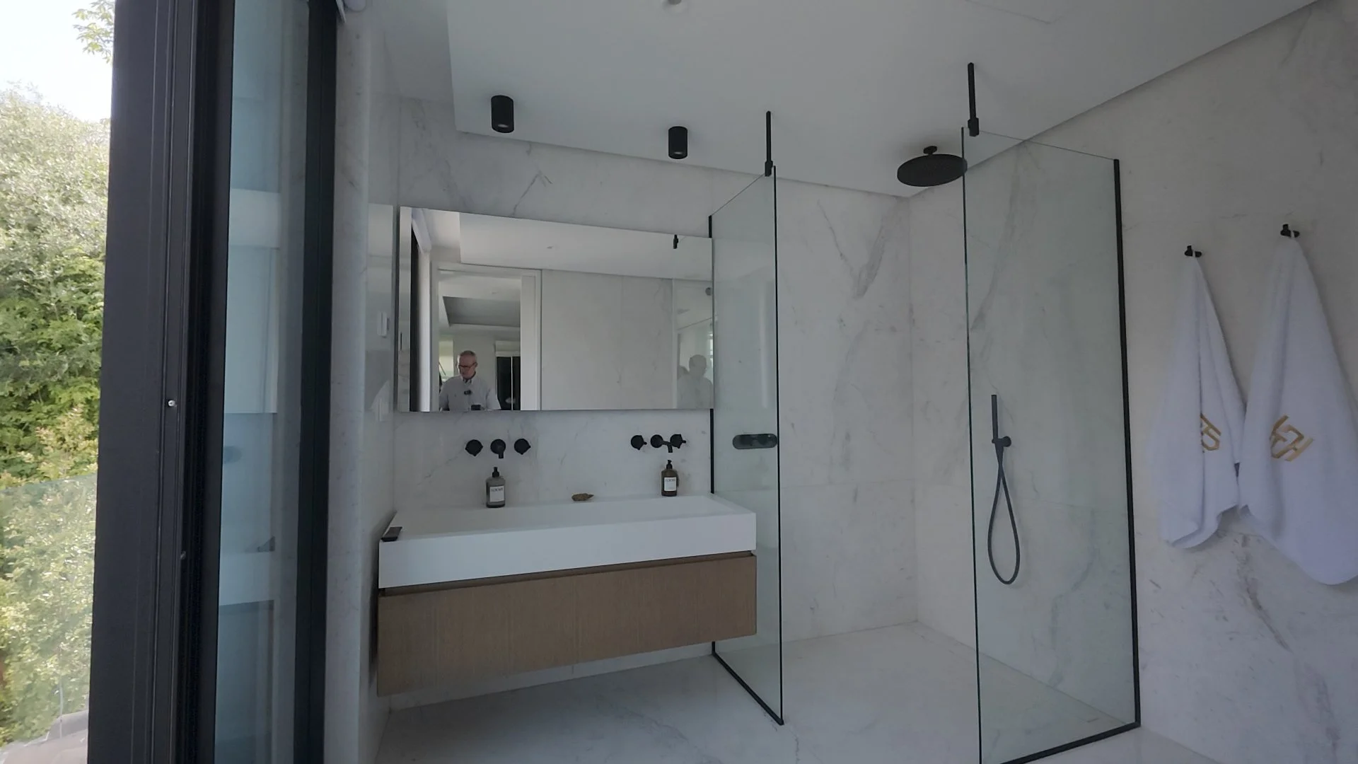 Modern spa-style master bathroom with freestanding tub and sea views..jpg