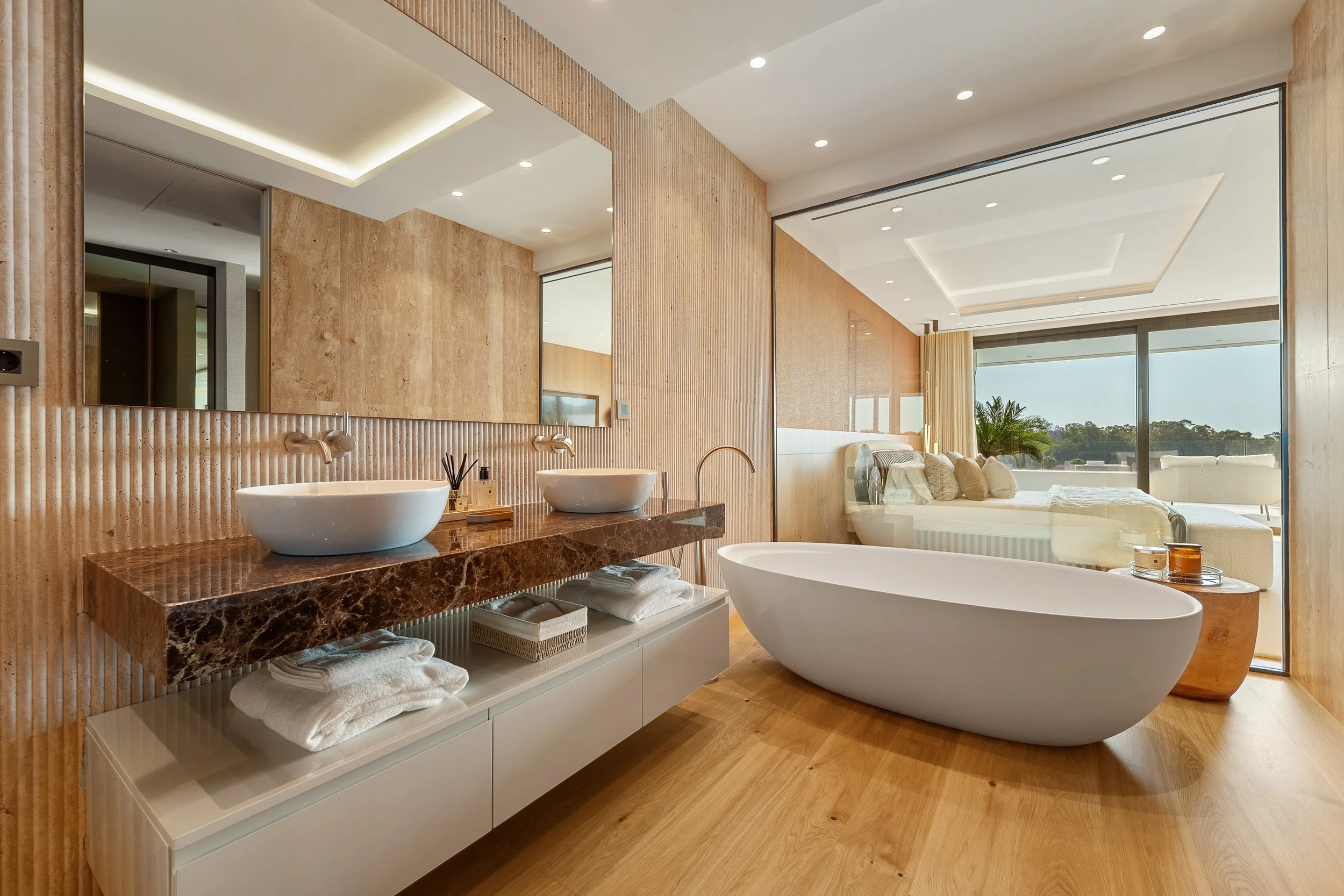 Luxury en-suite bathroom with dual vanities, marble accents, and soaking tub.