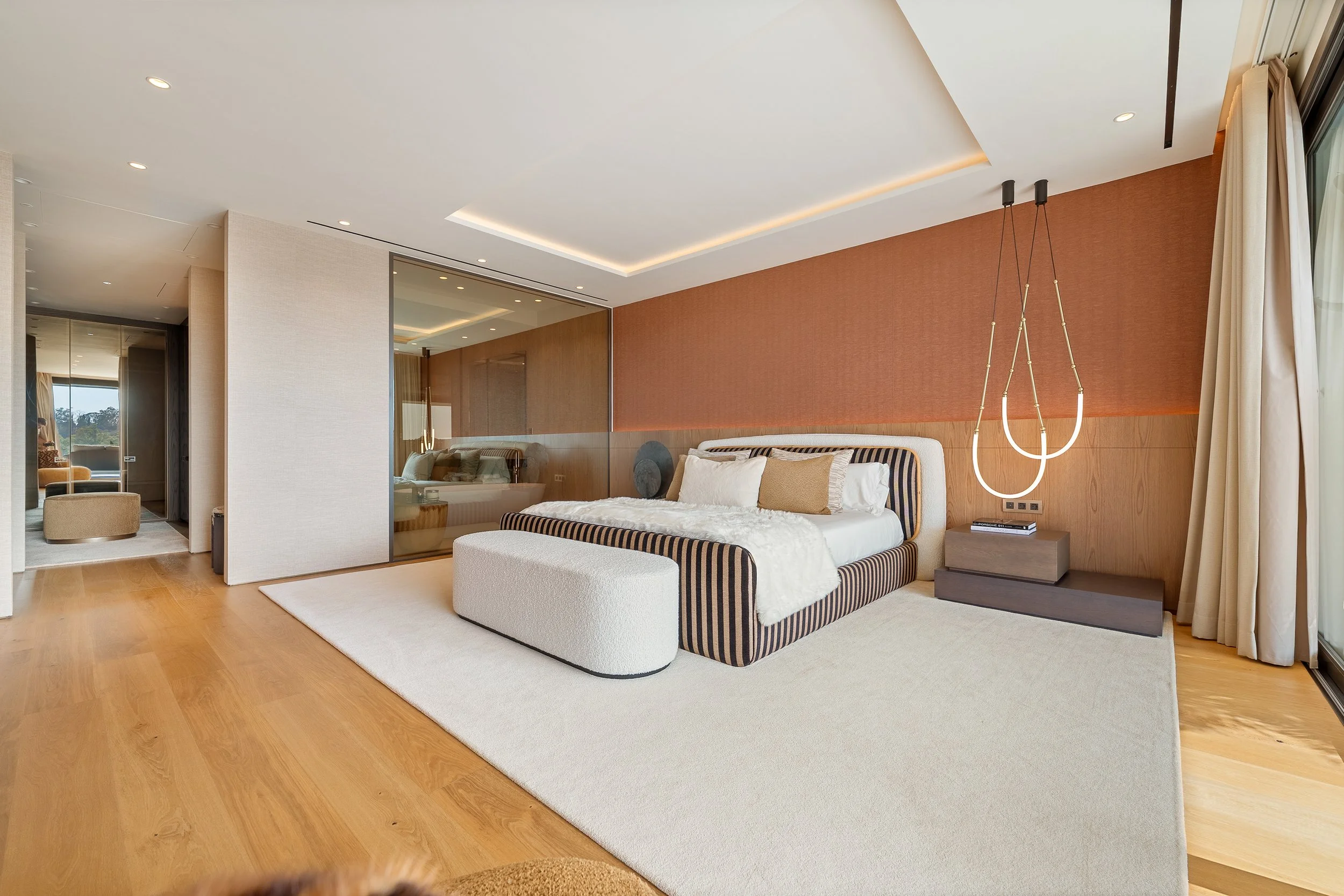 Sophisticated master suite with hardwood floors and panoramic window views