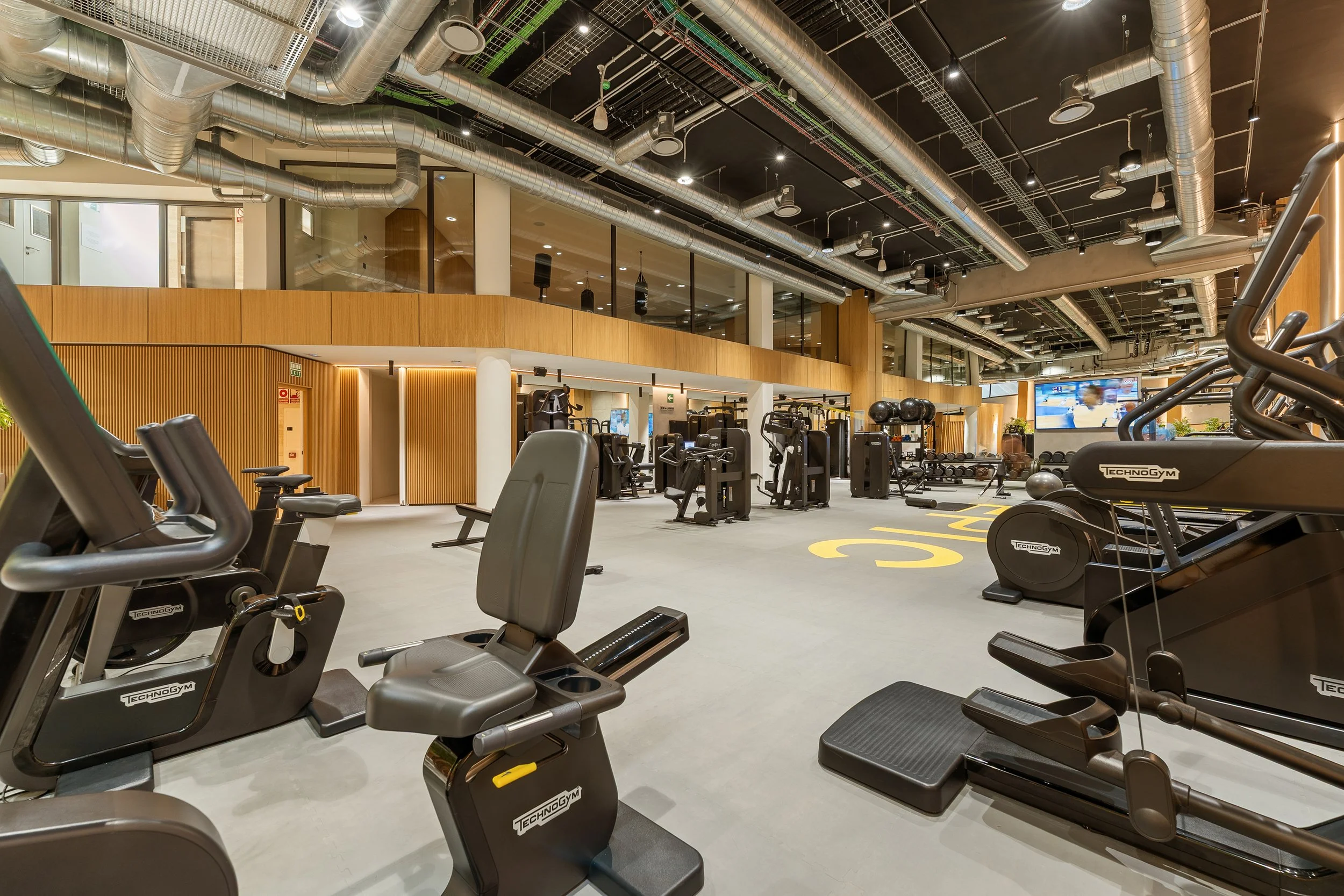 A wide-angle view of the gym area, showcasing an extensive selection of weight-training equipment and modern strength machines.