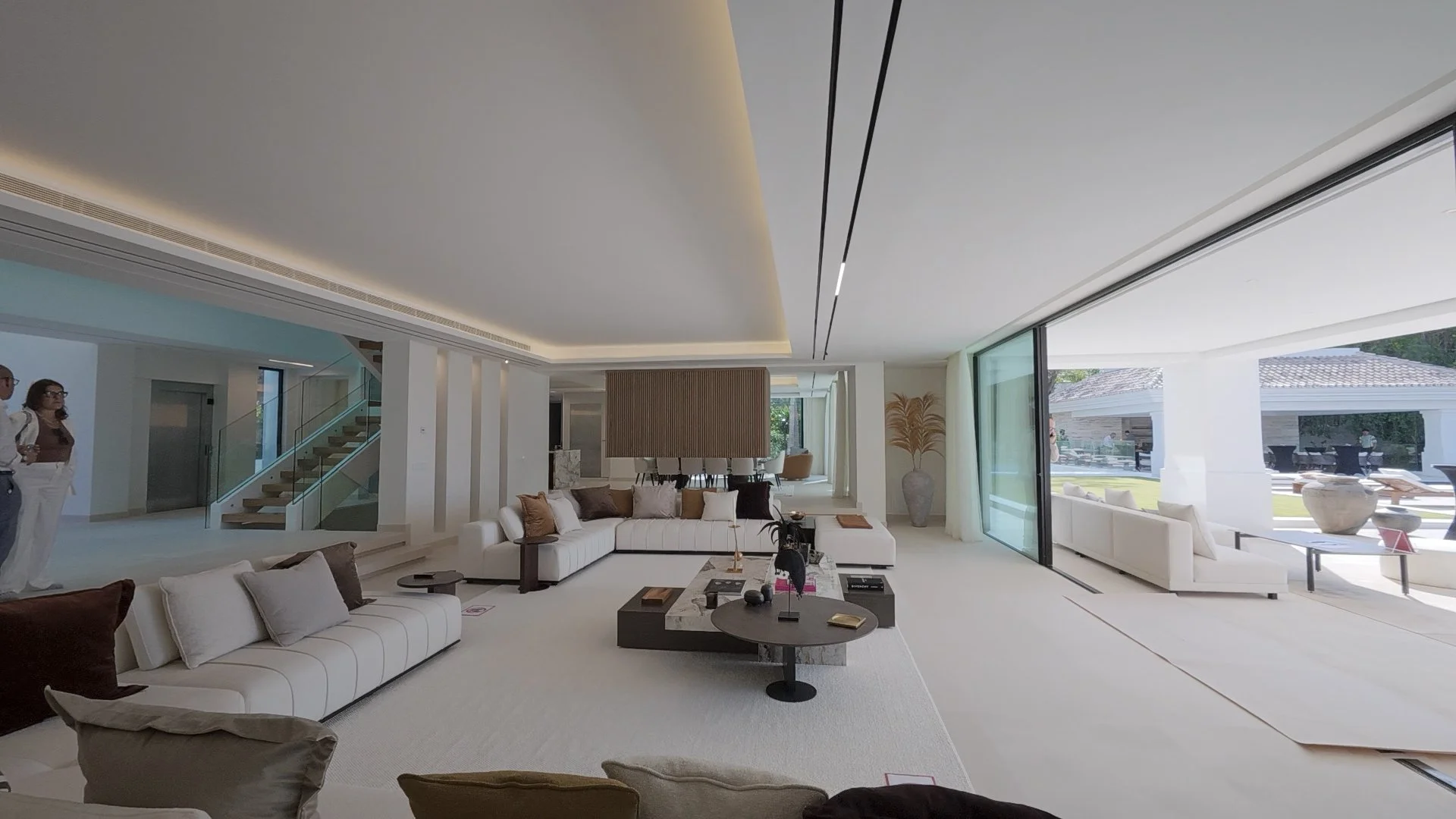Main Living Salon: A perspective of the vast, open-plan living room where floor-to-ceiling glass walls seamlessly merge the indoor luxury with the outdoor terrace