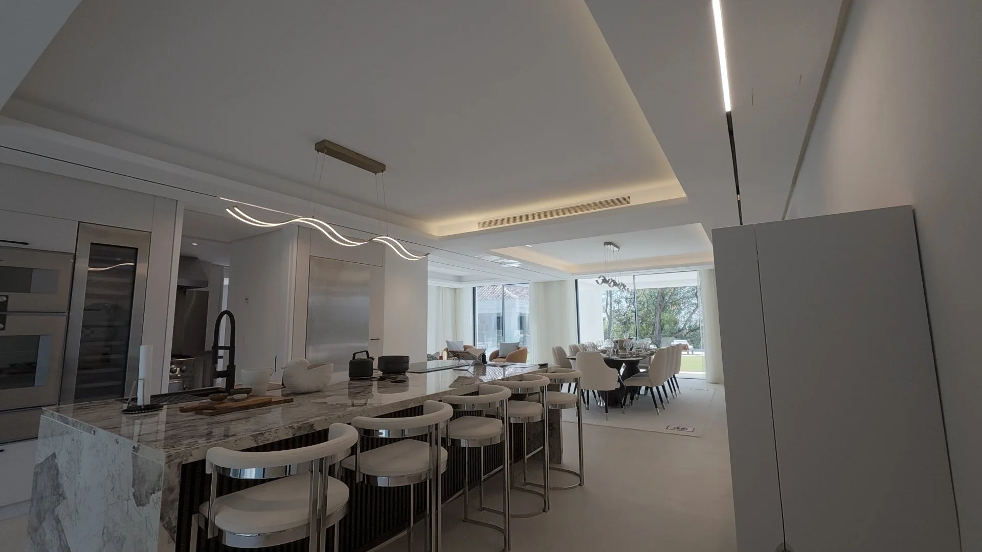 Gourmet Designer Kitchen: A screen capture of the minimalist kitchen, featuring a massive central island and professional-grade appliances integrated into the sleek cabinetry.