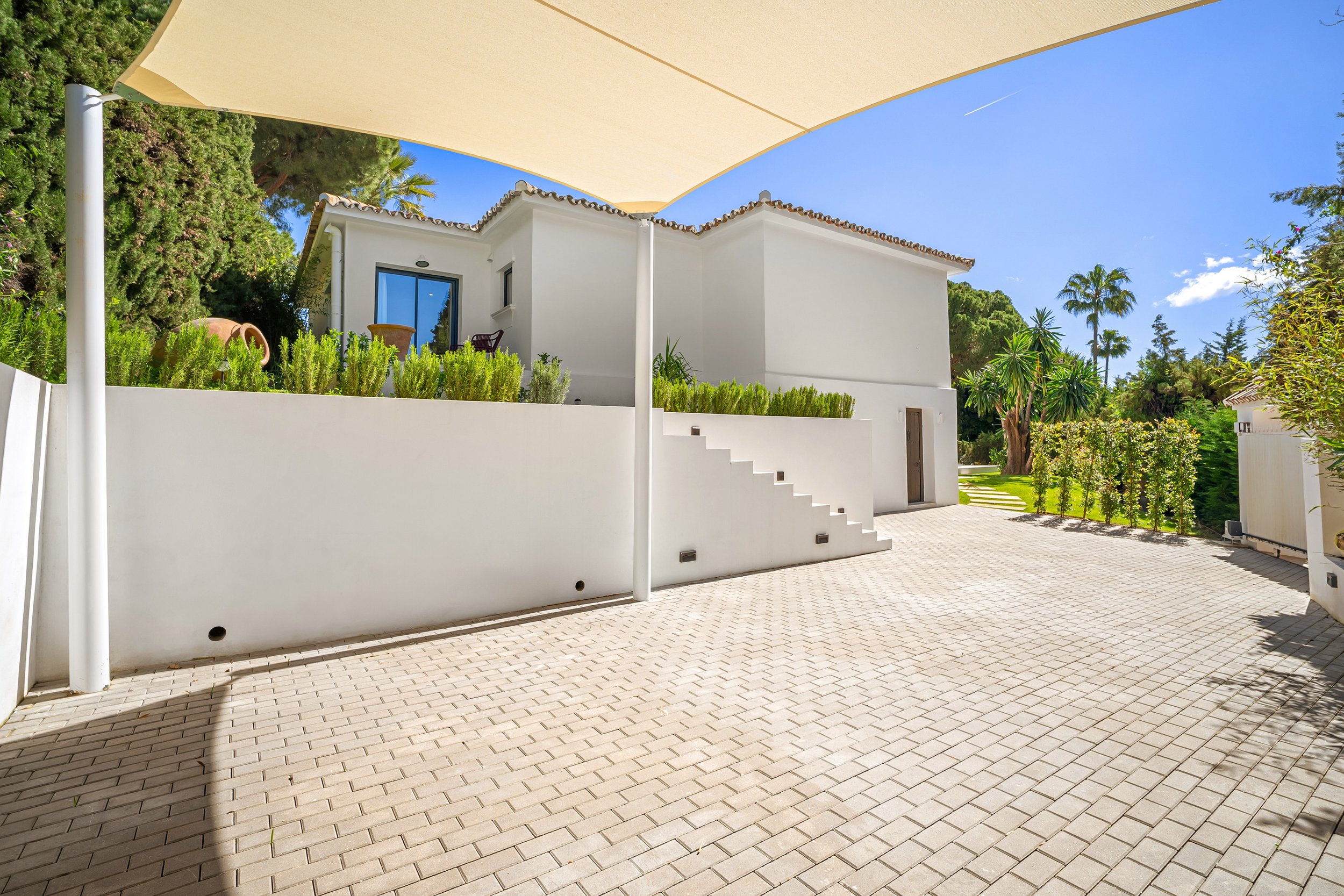 Secure private parking area for 2 cars with clean architectural lines and sun shading