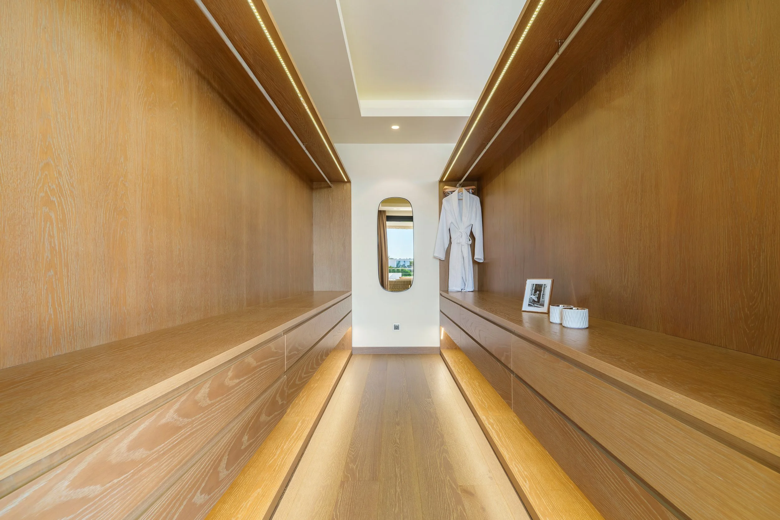 Custom-built wooden walk-in closet with integrated LED lighting and ample storage space in Los Olivos 2.
