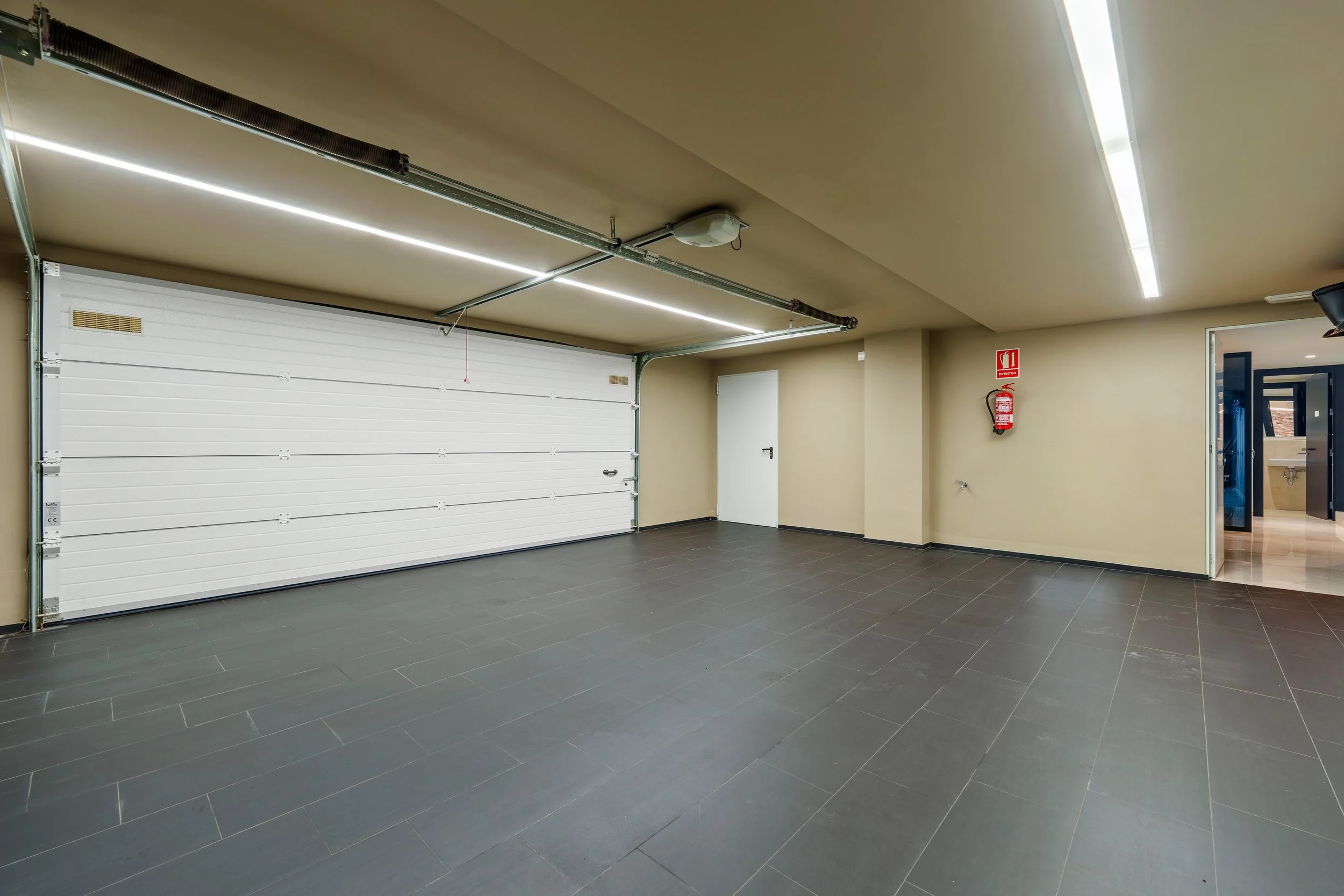 Secure underground private garage with polished dark floors and space for multiple luxury vehicles.