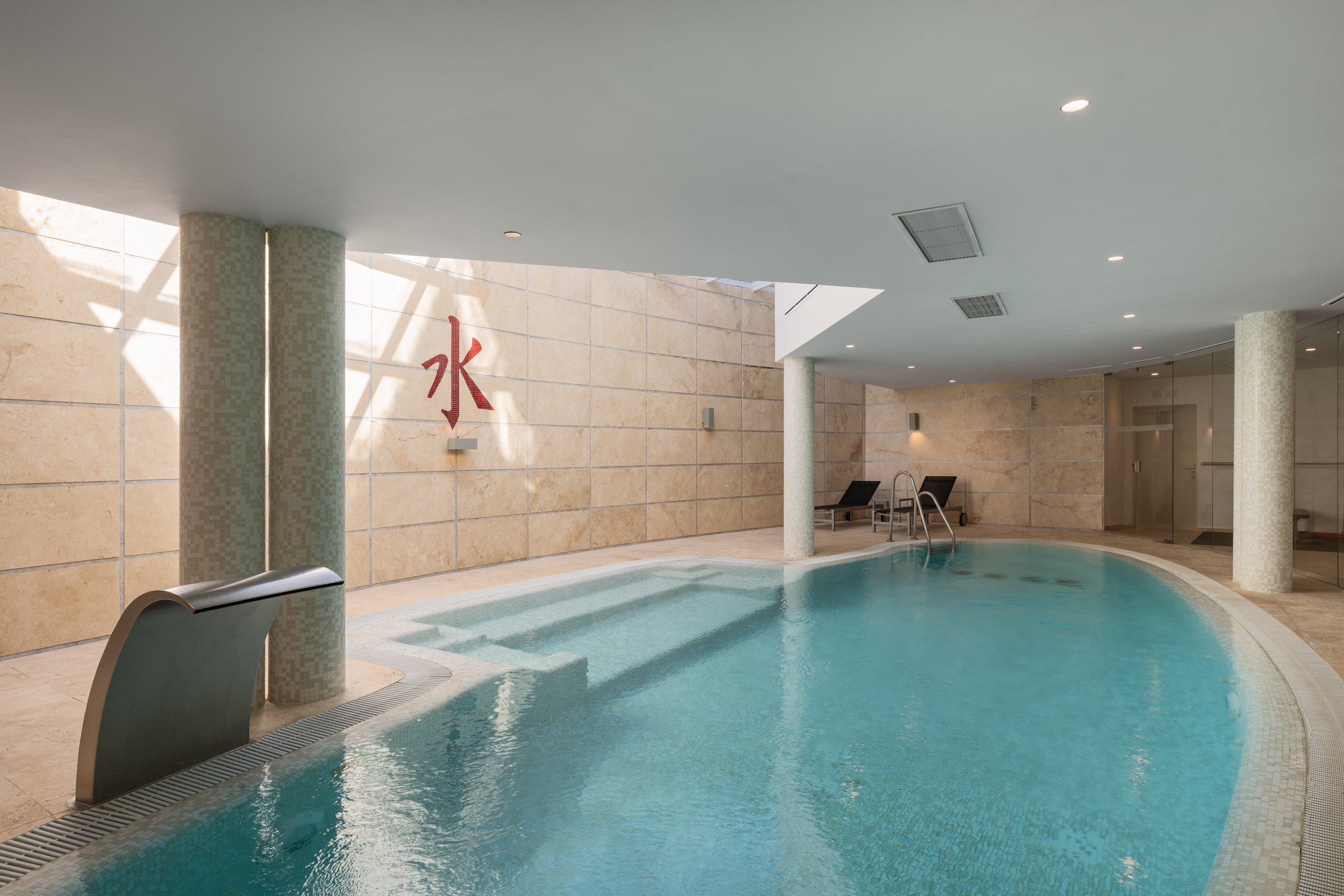 Luxurious communal indoor heated swimming pool and spa area at Meisho Hills, Sierra Blanca, featuring natural stone finishes and relaxing atmosphere.