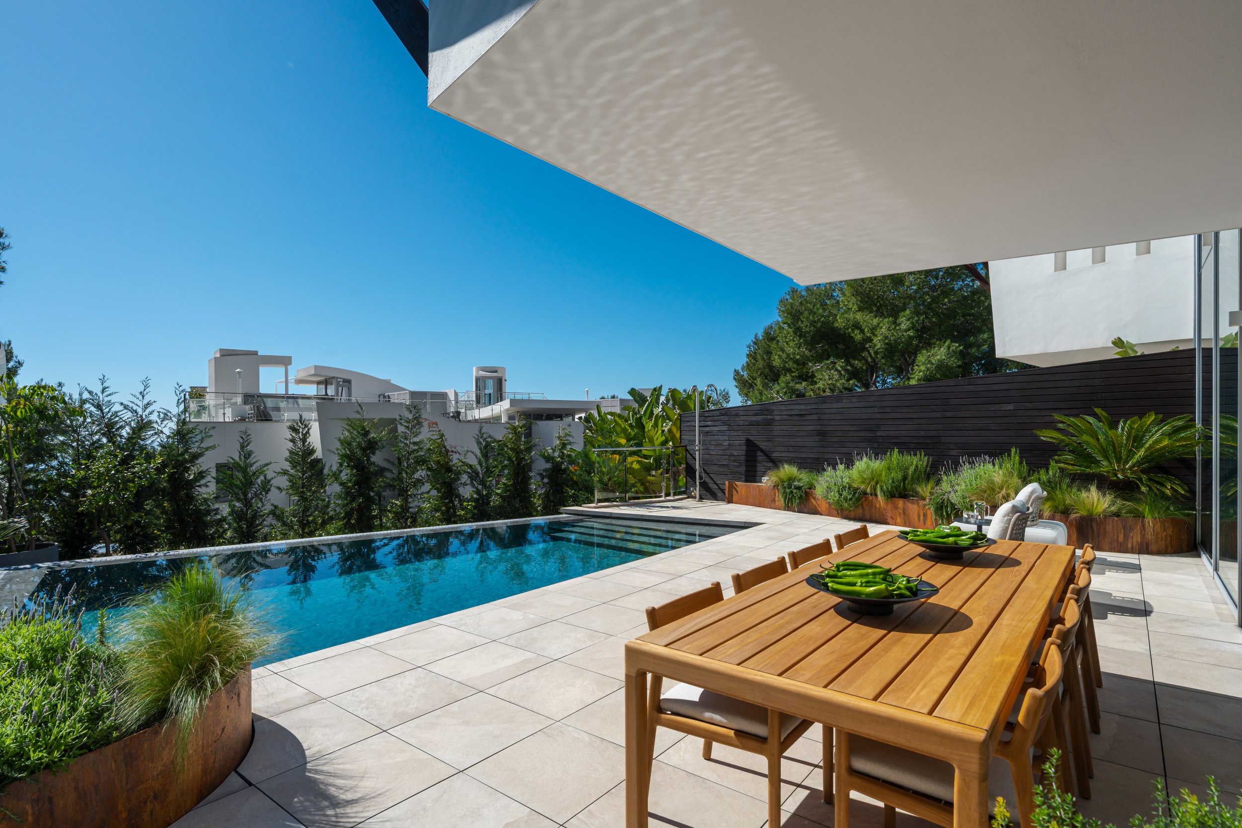 The primary outdoor living area of CMH2497S, featuring a private swimming pool and a shaded al fresco dining space.