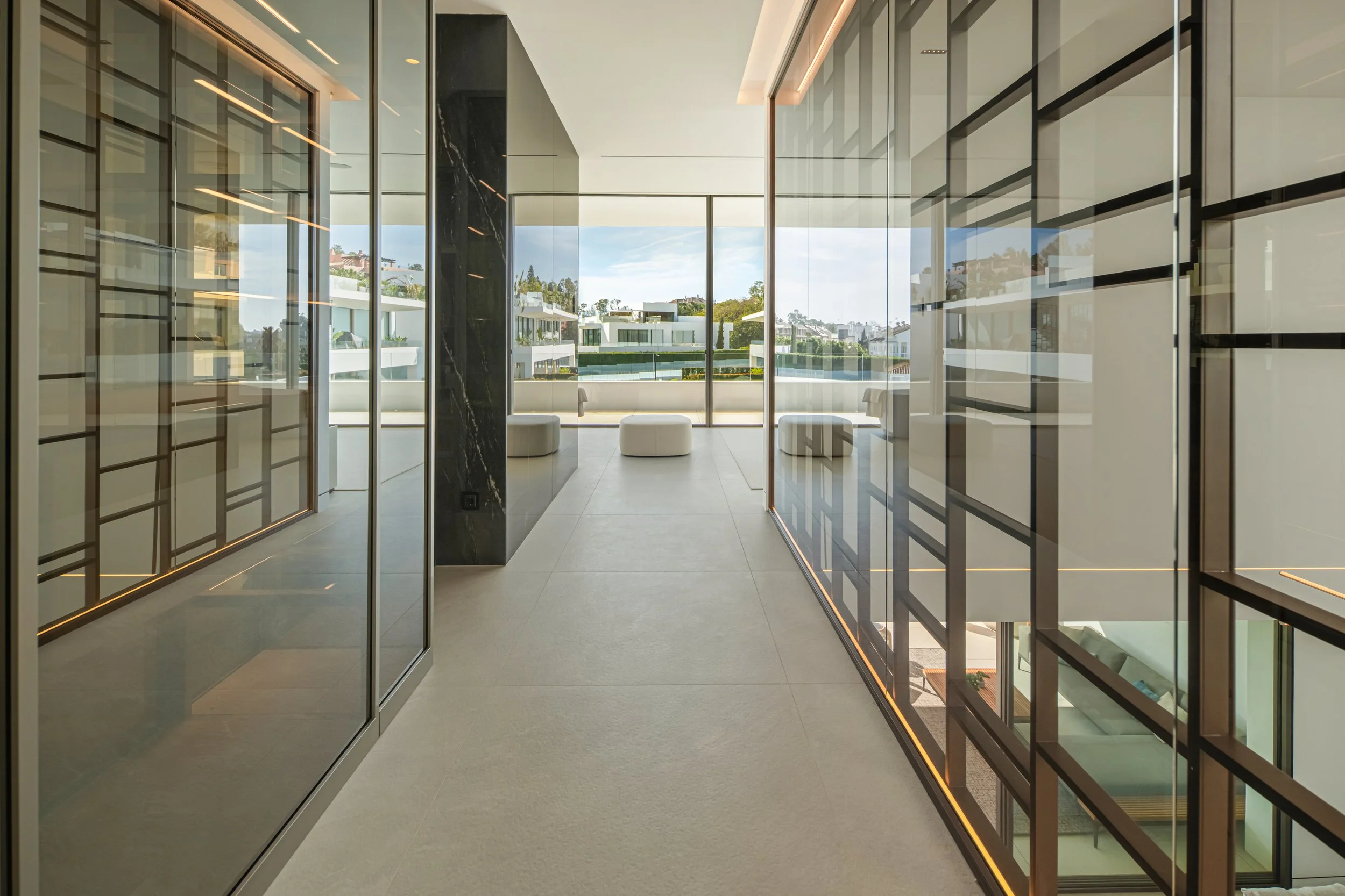 Designer corridor with integrated glass storage and high-gloss flooring leading to the private suites.