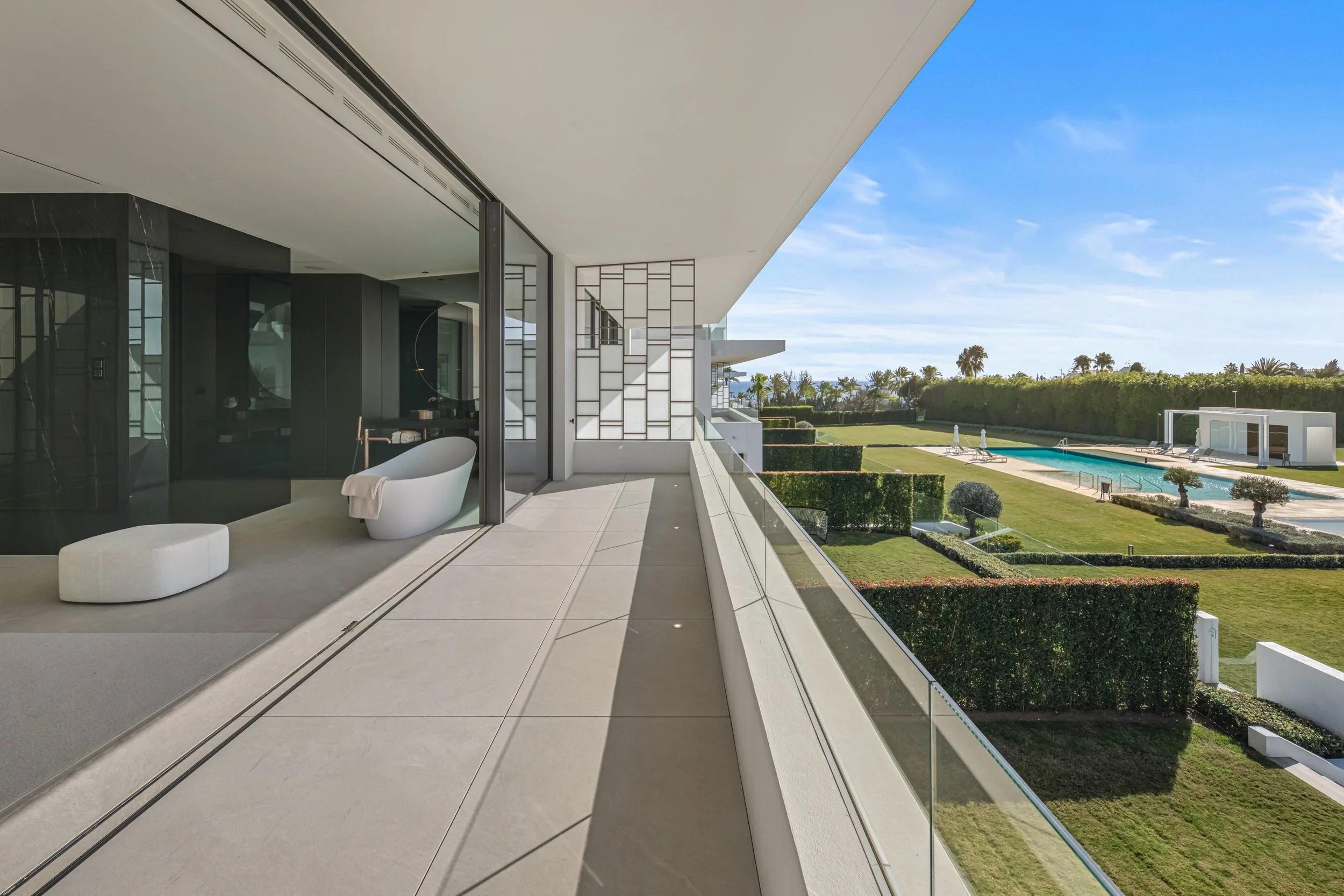 Upper-level terrace with glass railings offering panoramic views of the Golden Mile and private community pool.