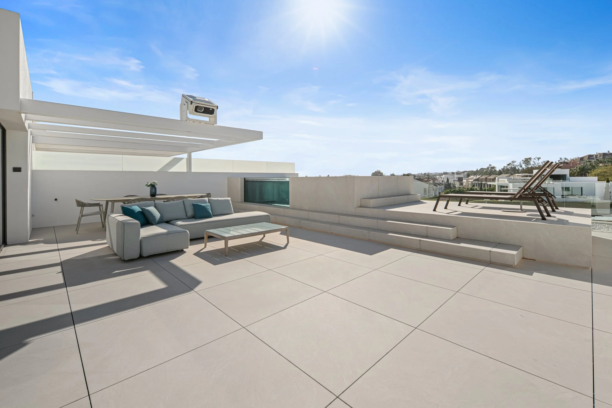 Expansive rooftop deck with comfortable lounge seating and sunbeds for ultimate relaxation.