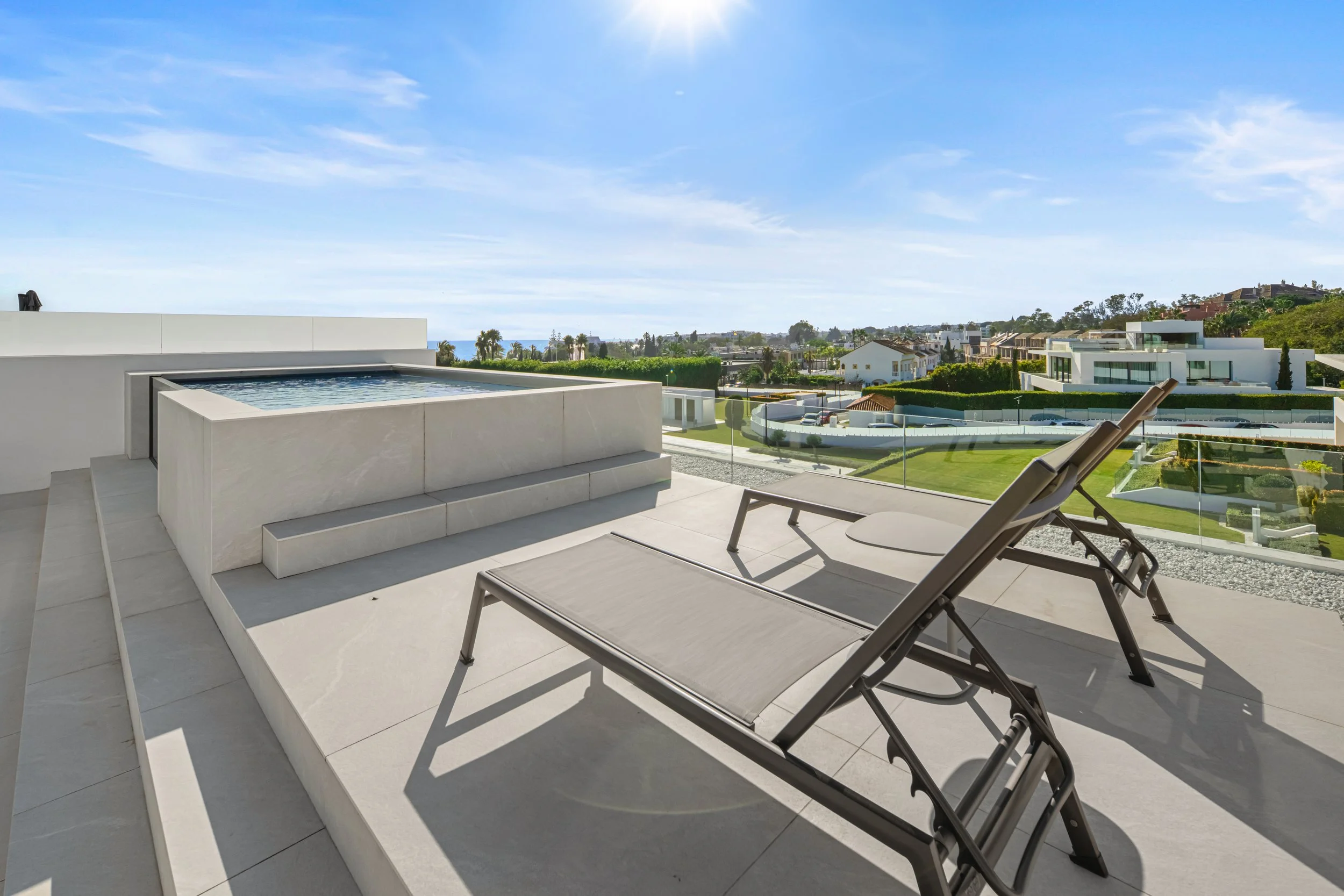Tiled rooftop solarium highlighting the private plunge pool and elevated views toward the Mediterranean.