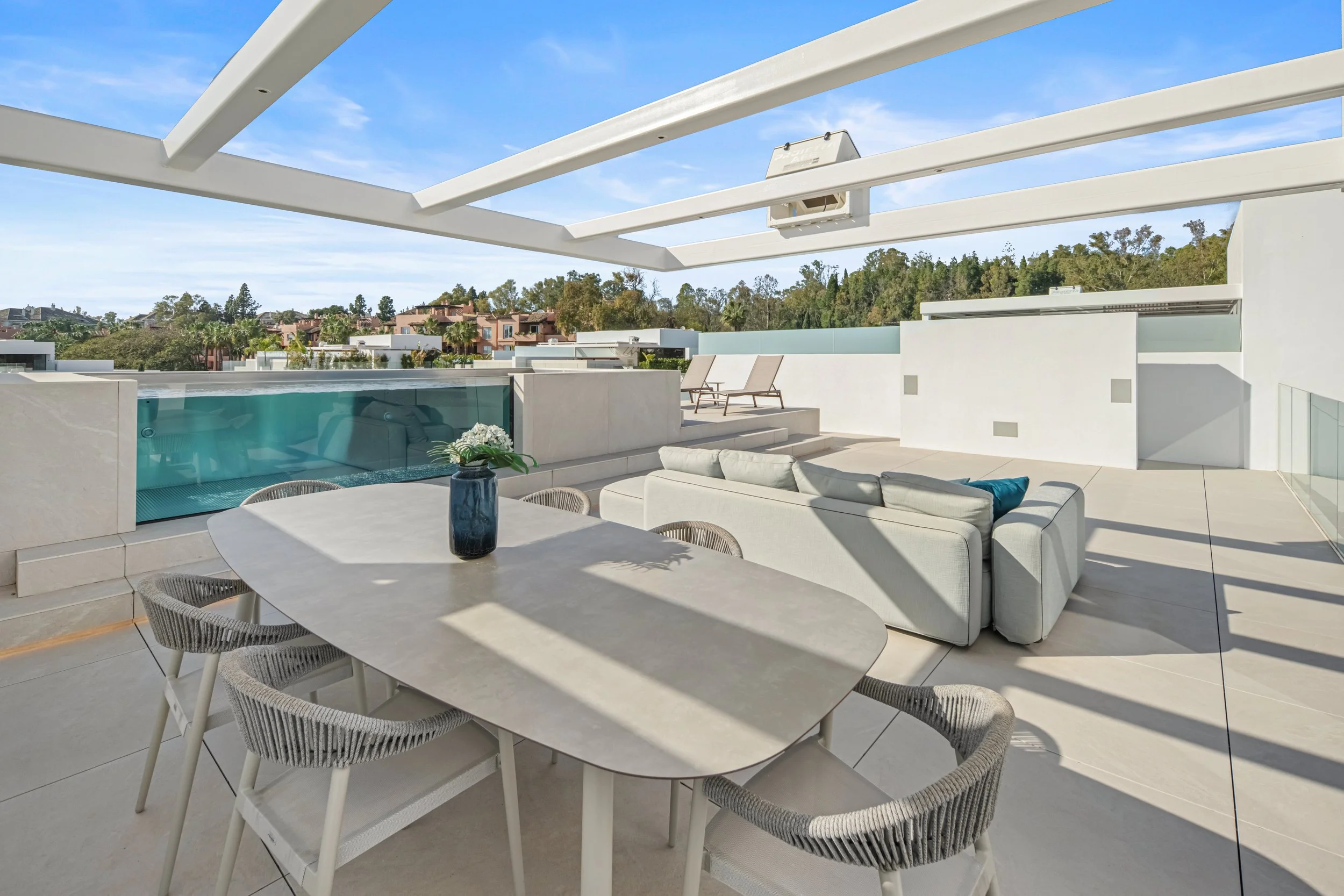 Outdoor dining area under a modern pergola on the rooftop terrace, ideal for sunset cocktails.