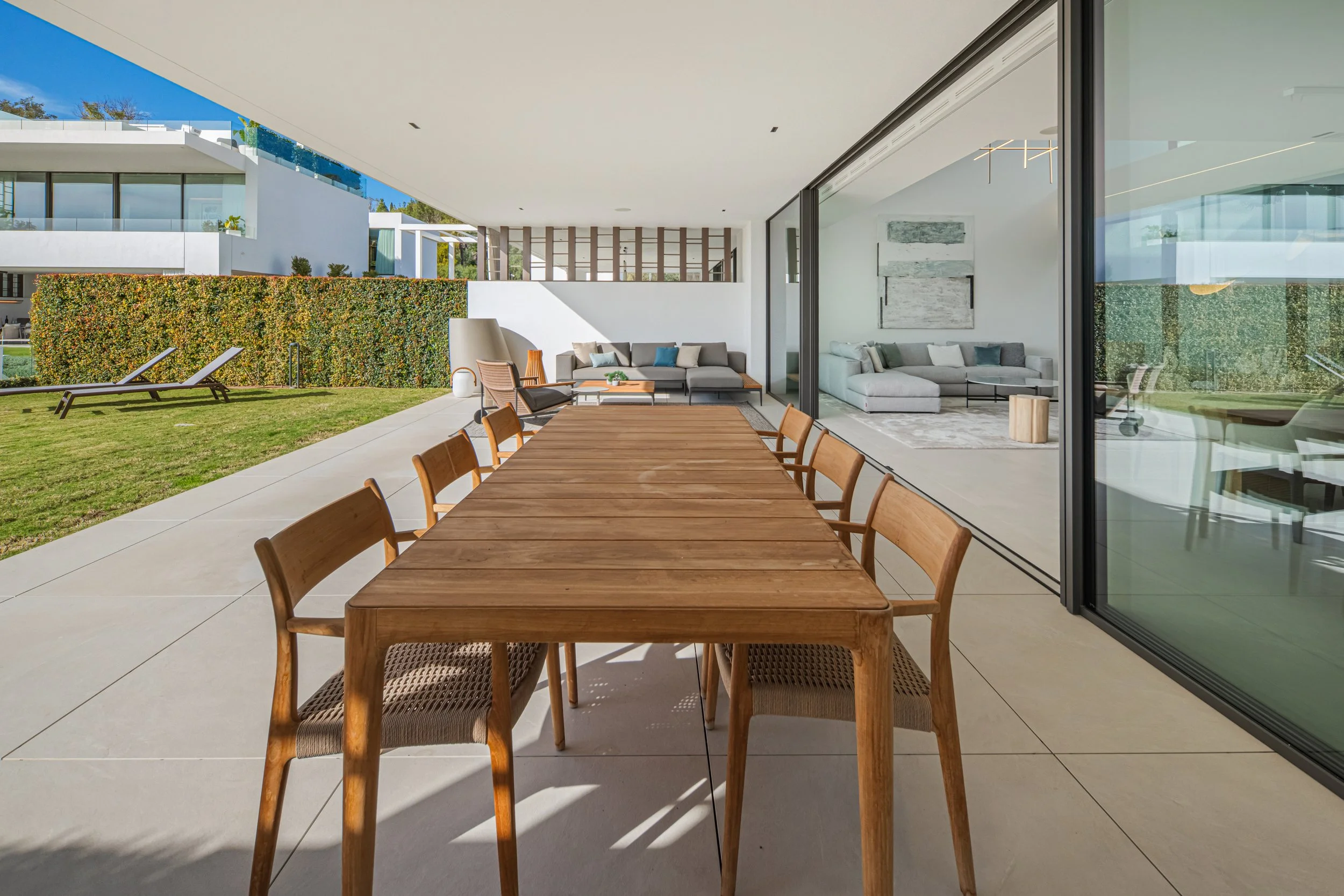 Spacious covered terrace featuring a large wooden dining table, perfect for Mediterranean outdoor entertaining.