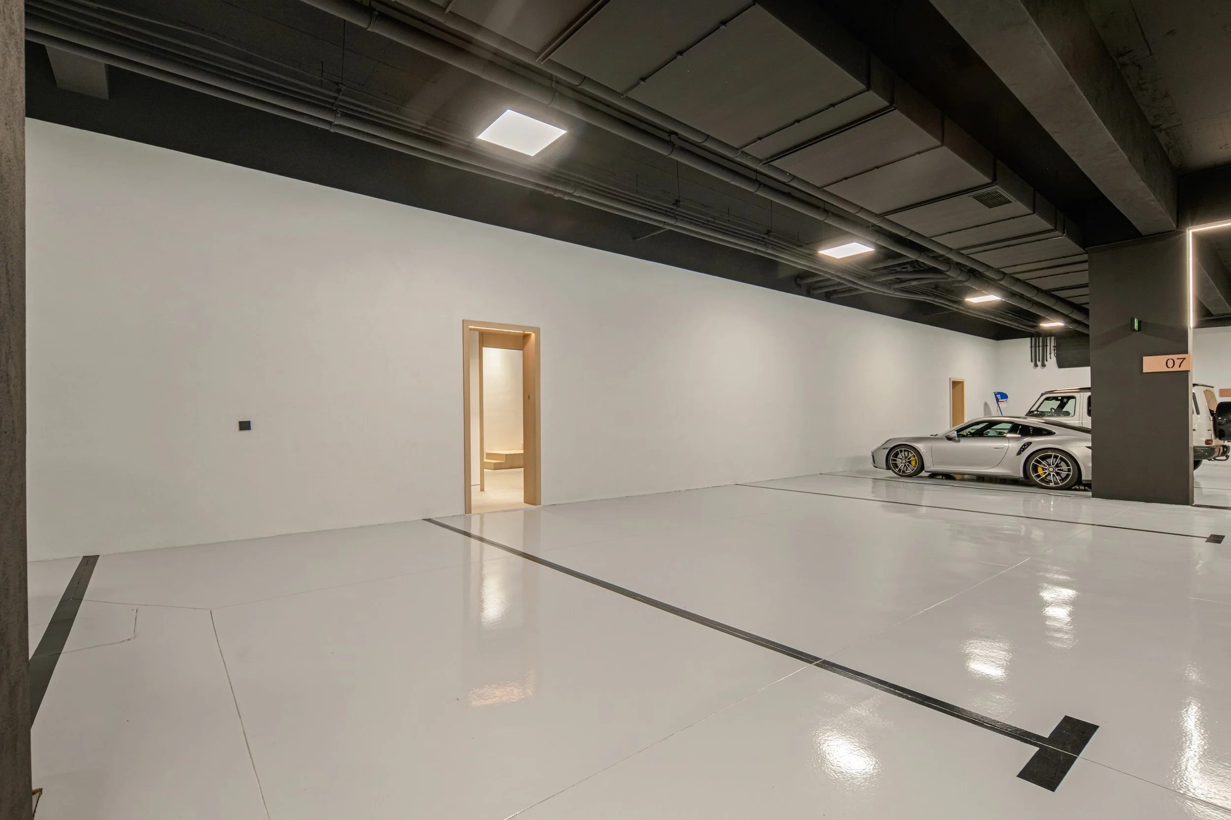 Pristine 4-car private underground garage with high-gloss white floors and professional lighting