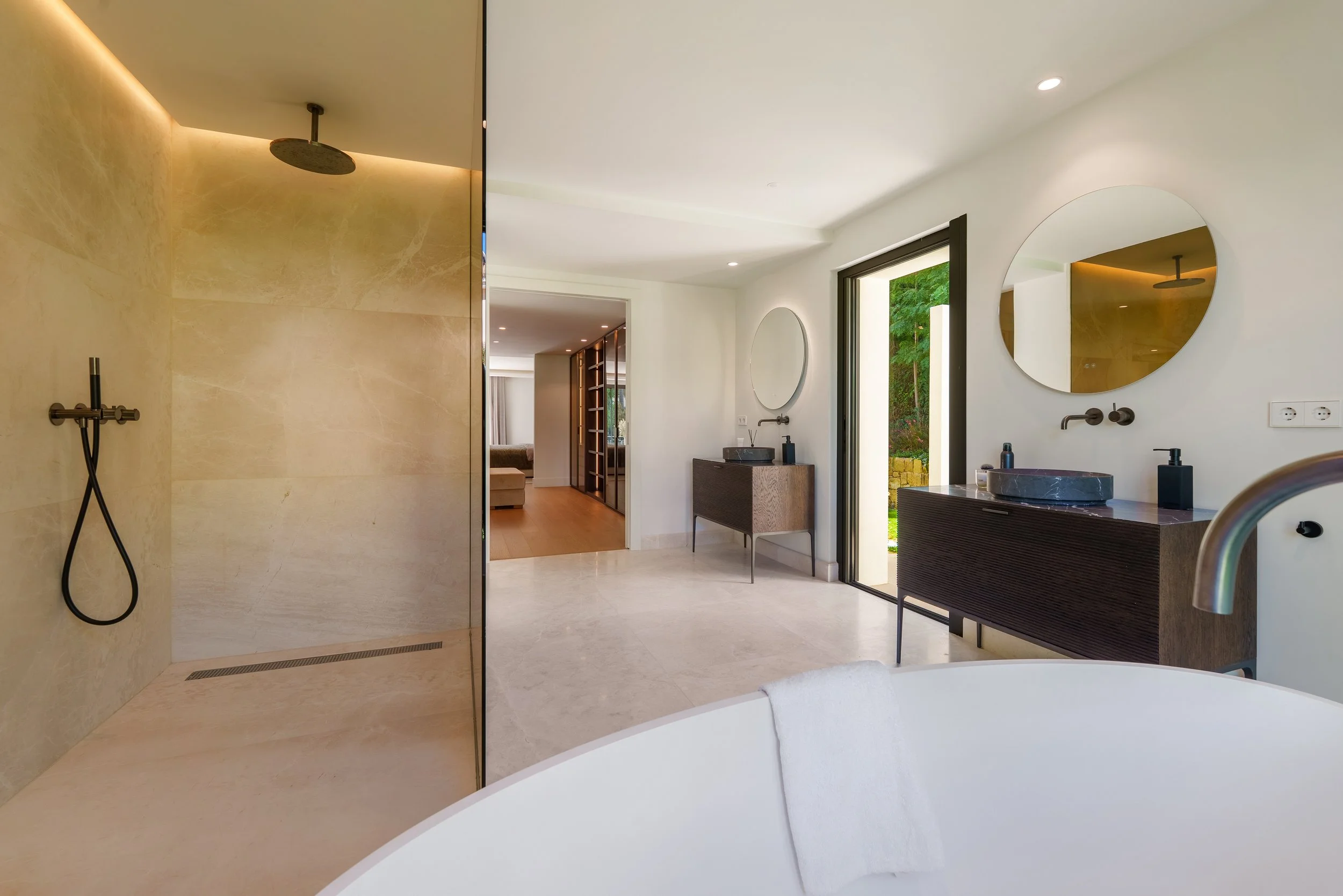 Spa-like en-suite bathroom with a rainfall shower and natural stone tiling.