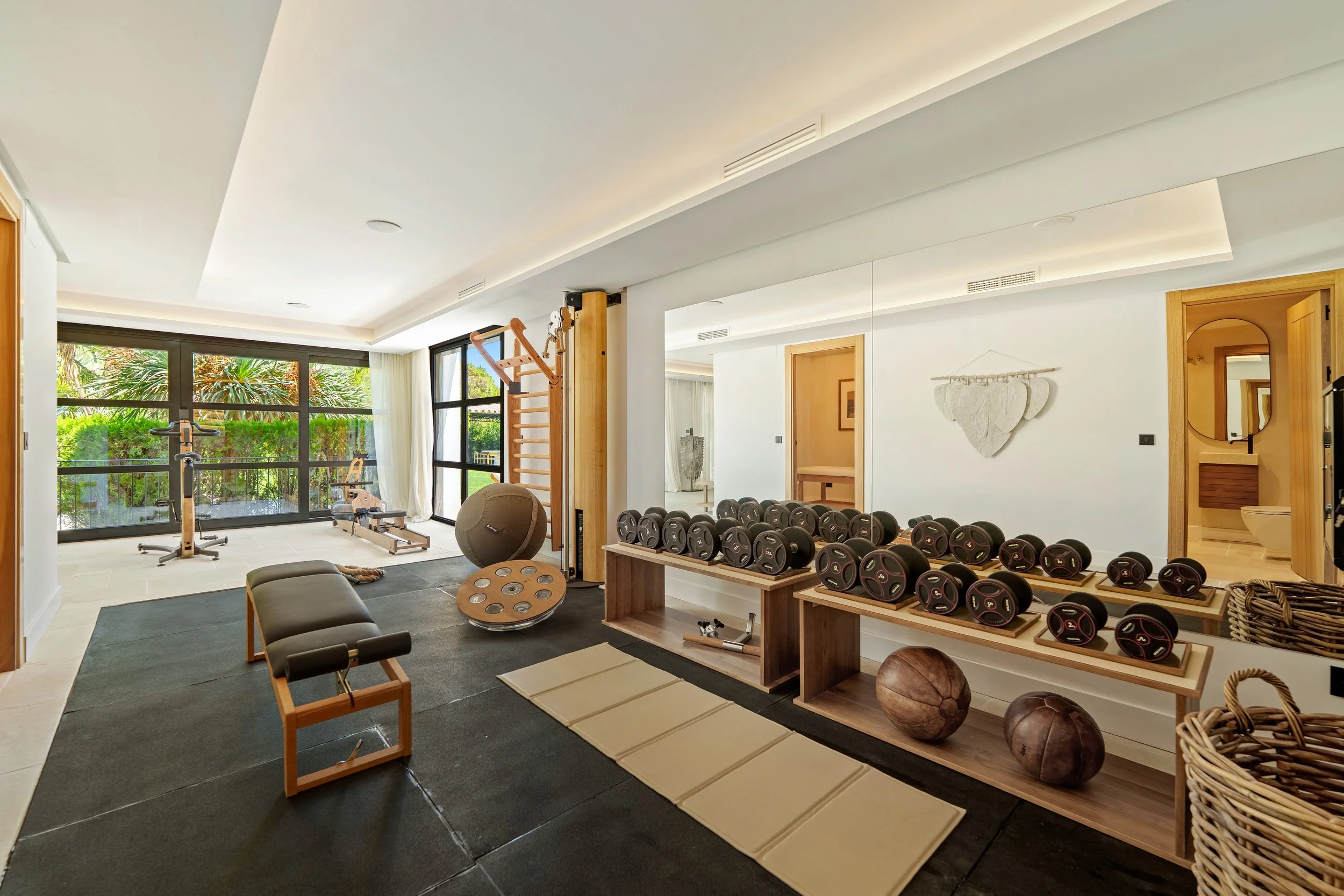 State-of-the-art home gym with glass walls facing the internal courtyard and natural light.