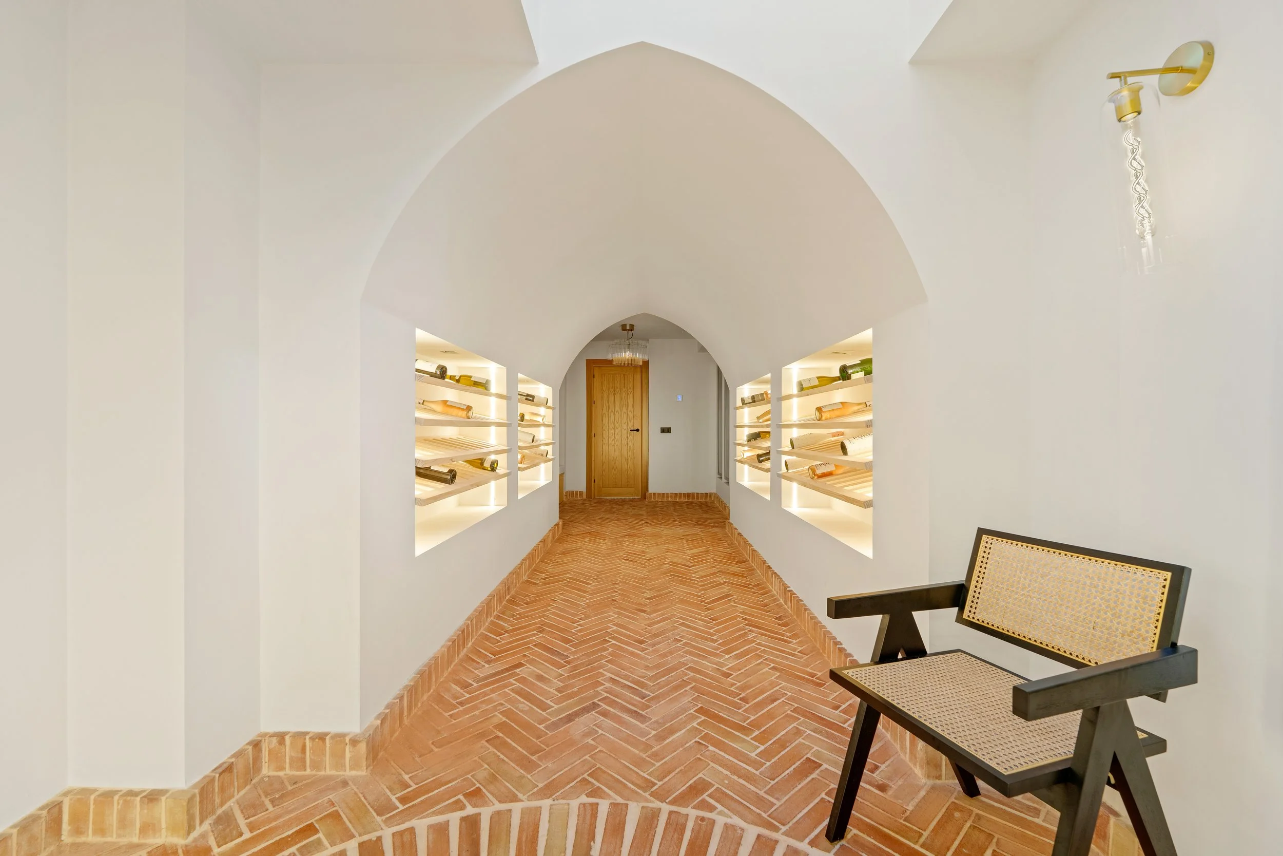 Custom wine bodega with climate control, LED backlighting, and floor-to-ceiling bottle displays.
