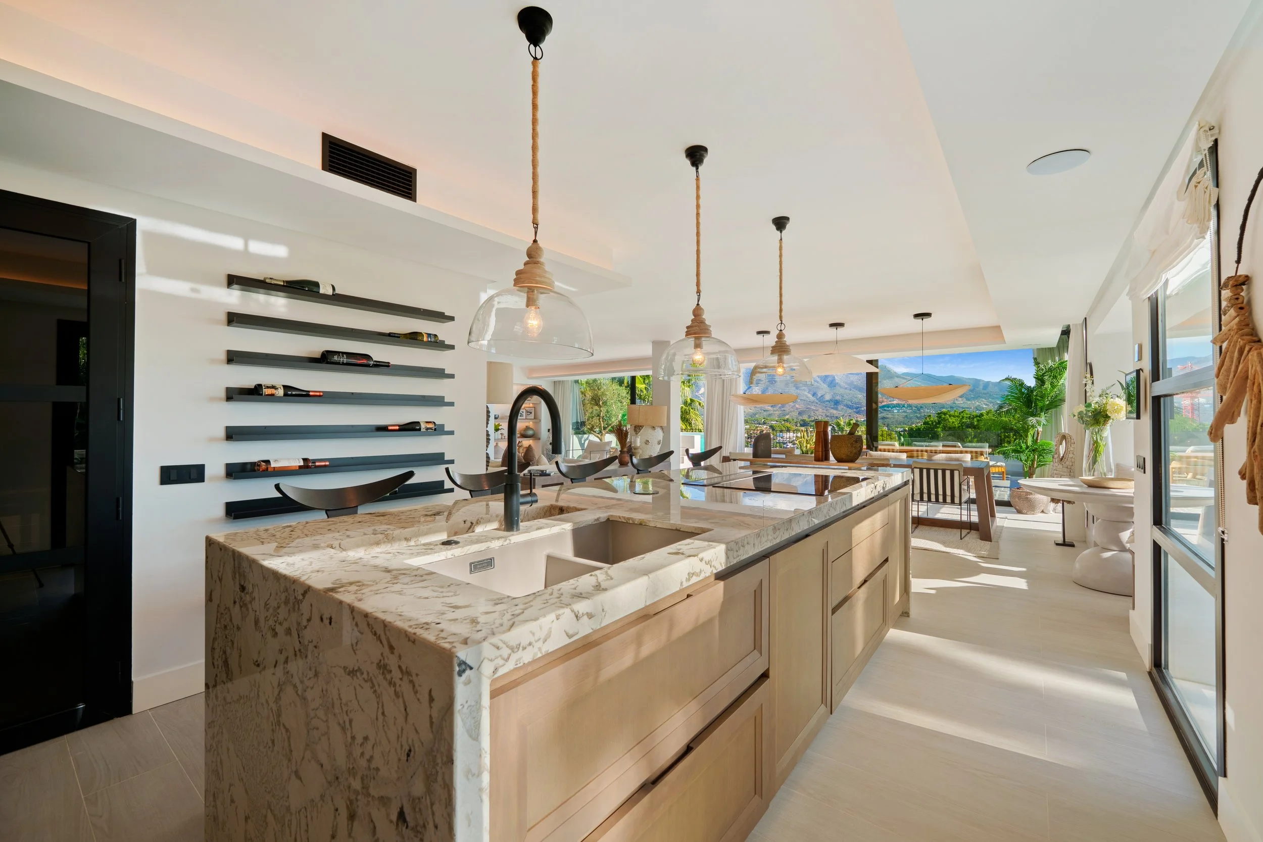 Modern designer kitchen with a large central island, high-end appliances, and direct garden access.