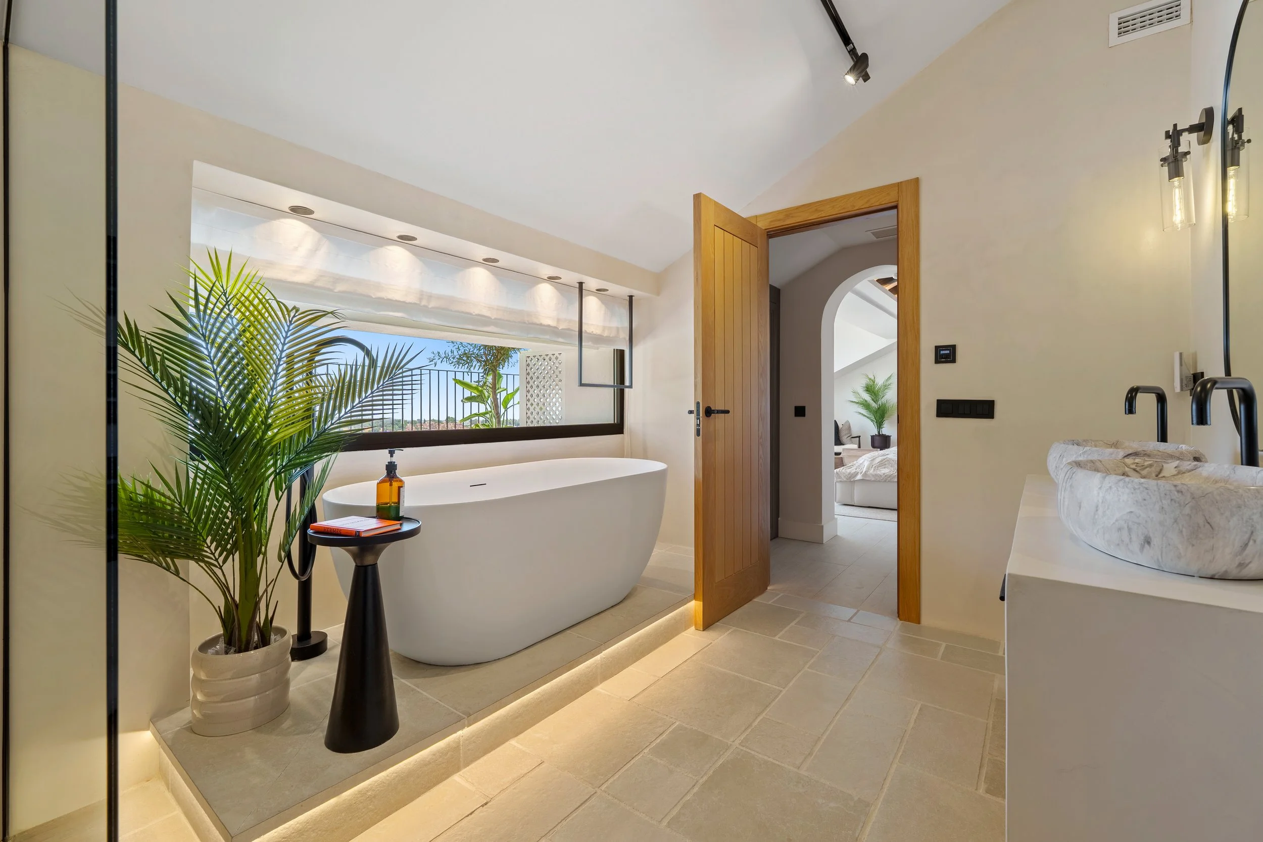 Luxury ensuite bathroom with a freestanding soaking tub, marble finishes, and double vanity.