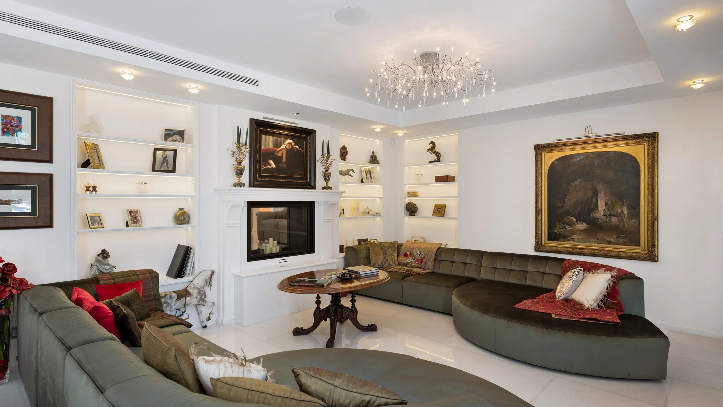 Modern living room interior in La Cerquilla with curved white sofa sleek fireplace and recessed shelving Ref CMH2440