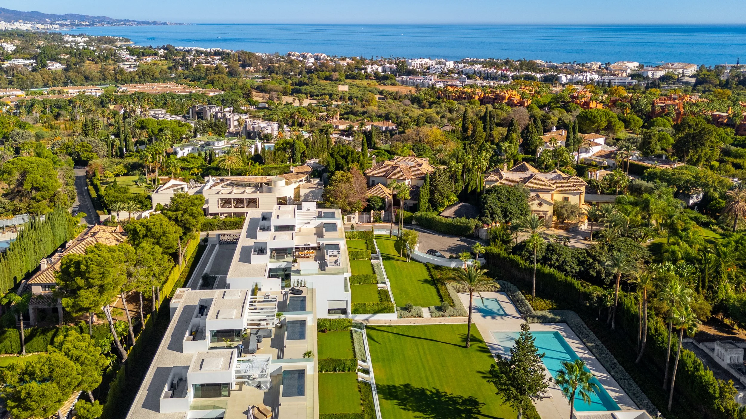 Aerial View: Aerial view of contemporary white villas with blue pools in Nueva Andalucía