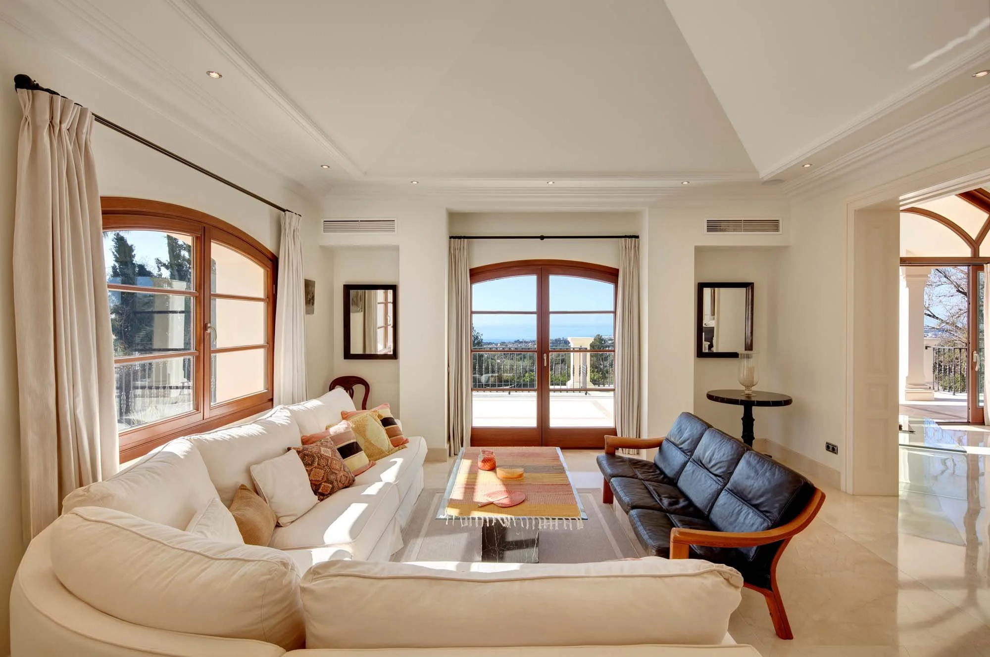 Elegant upper-floor sitting room with warm wood-framed windows and private terrace access.