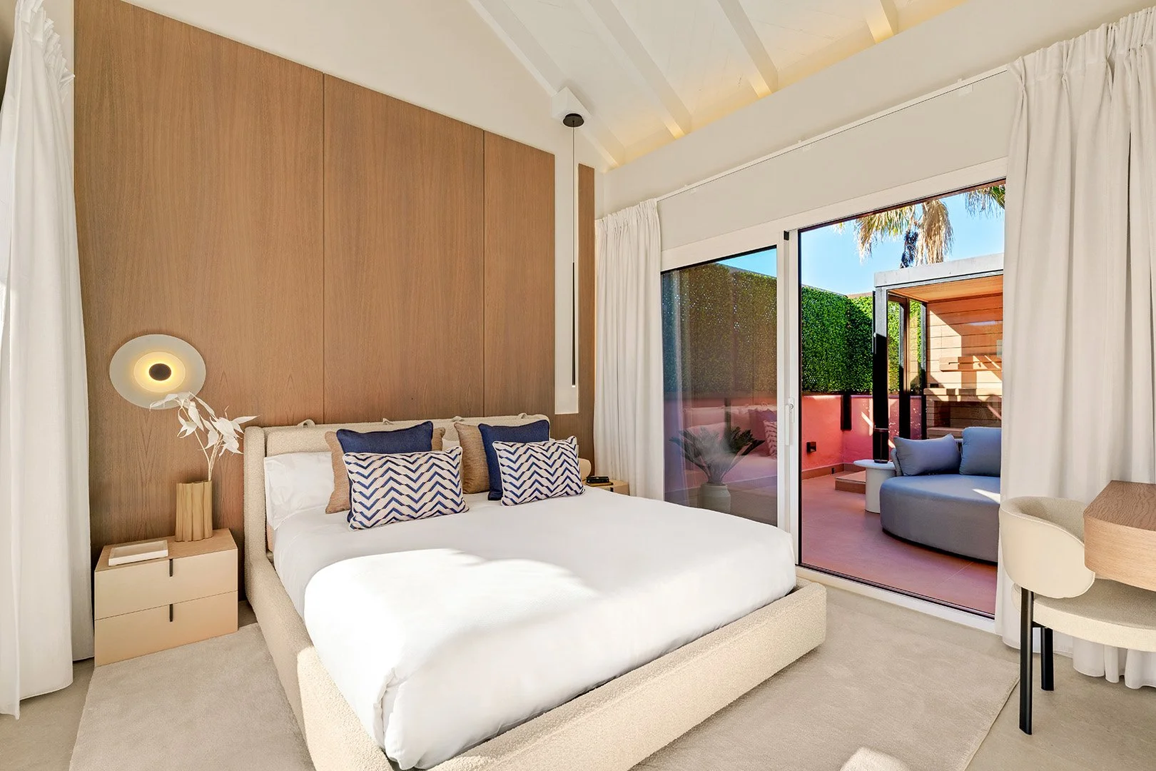 Master Sanctuary: A serene retreat featuring natural wood wall paneling, vaulted ceilings, and direct access to a private sun terrace.