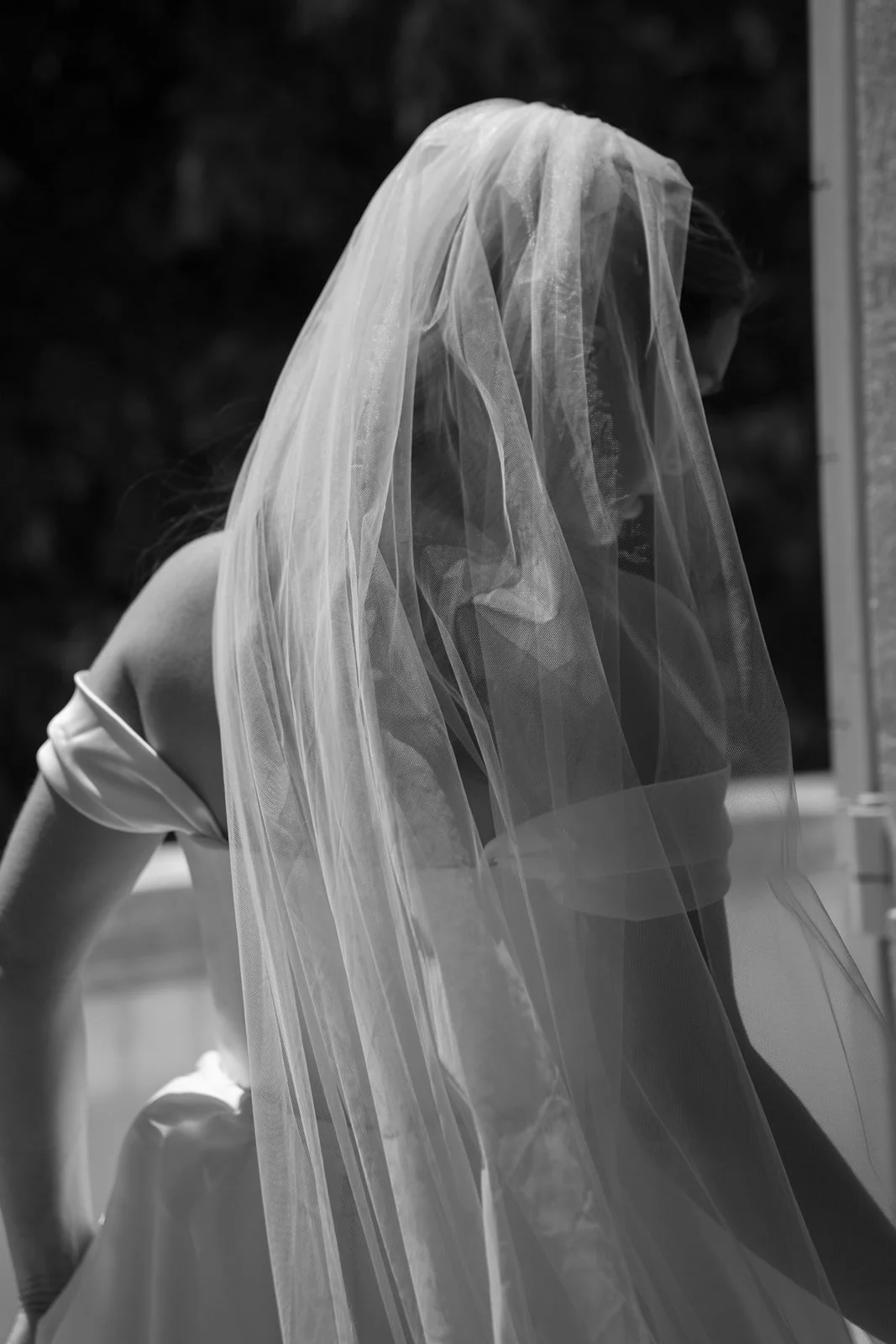 Bride wearing a bridal veil and a strapless dress on her way to her first look and her wedding ceremony.