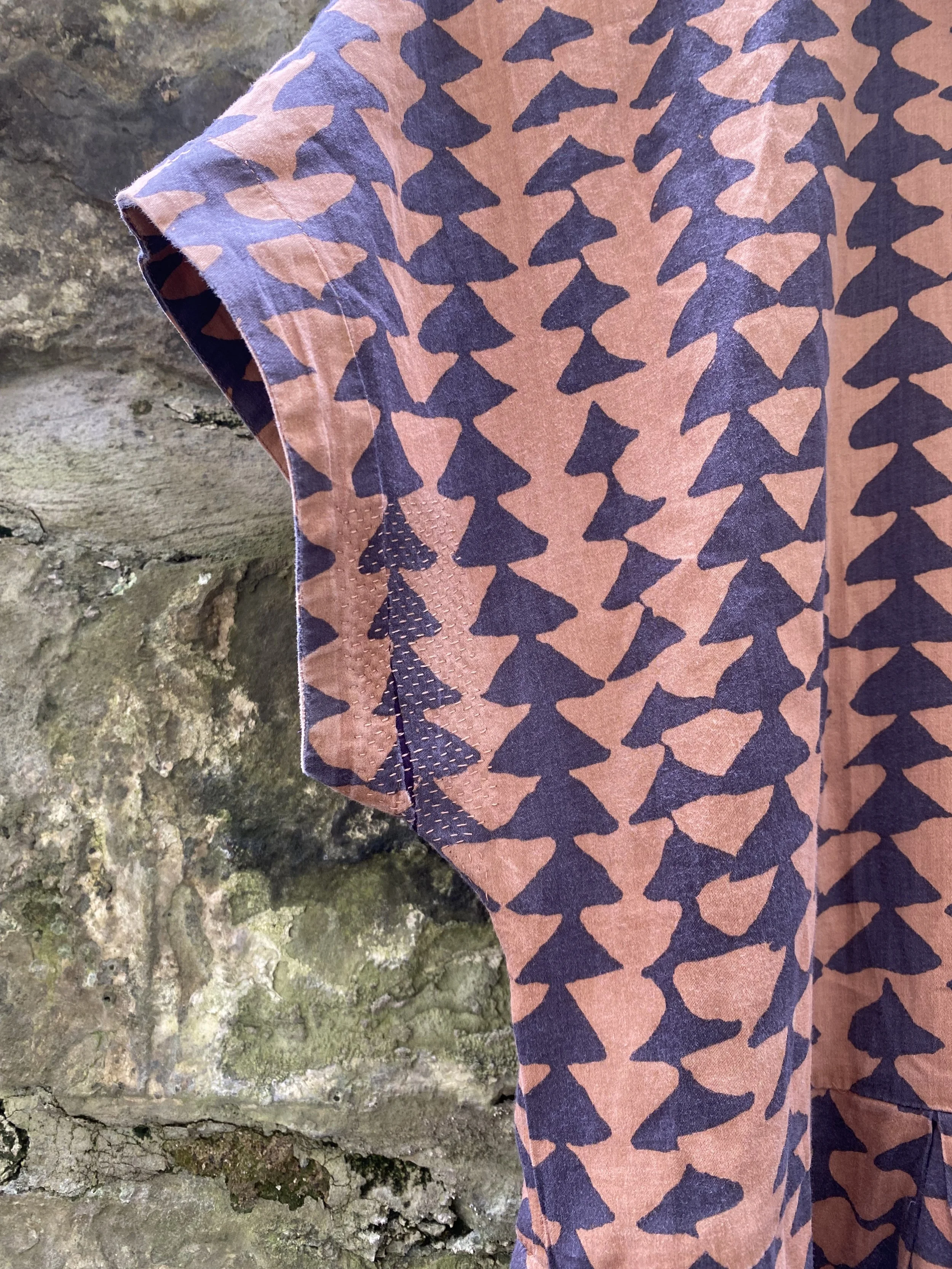 Discreet repair on pink and purple triangle print shirt dress, patch on reverse, sashiko stitching on top