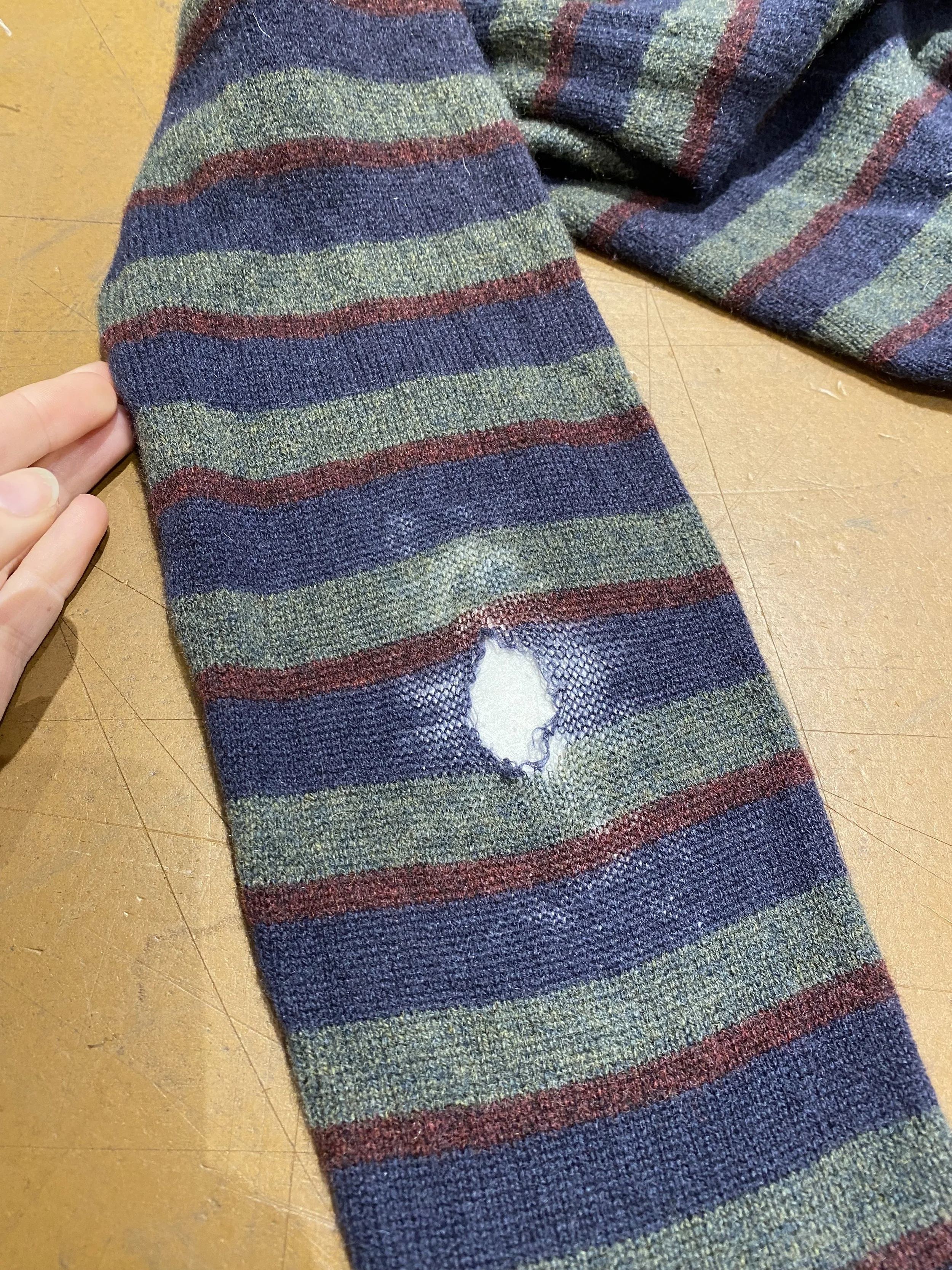 Elbow hole in knitted jumper