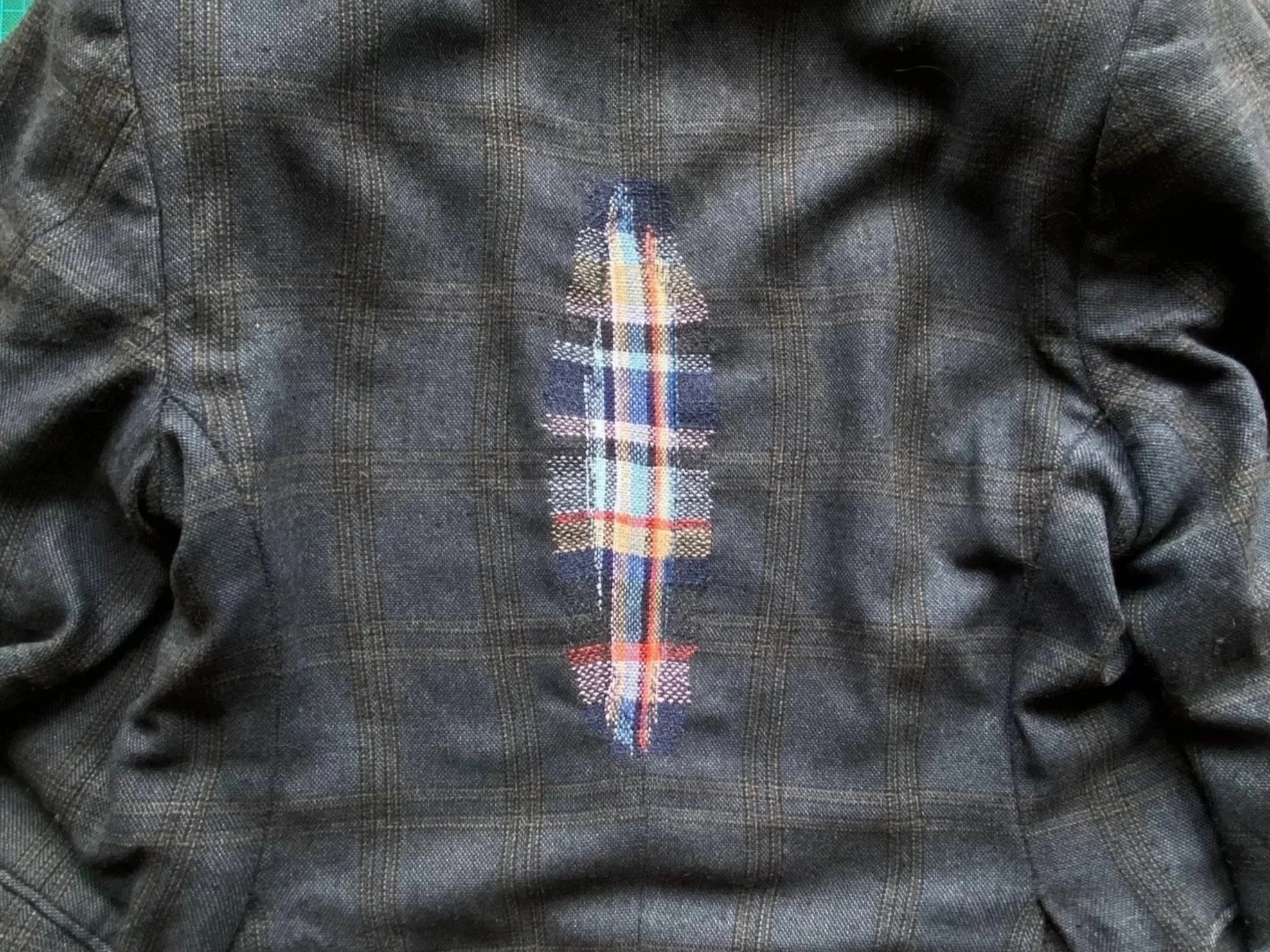 Visible mend on wooden blazer: Full shot of finished woven darn