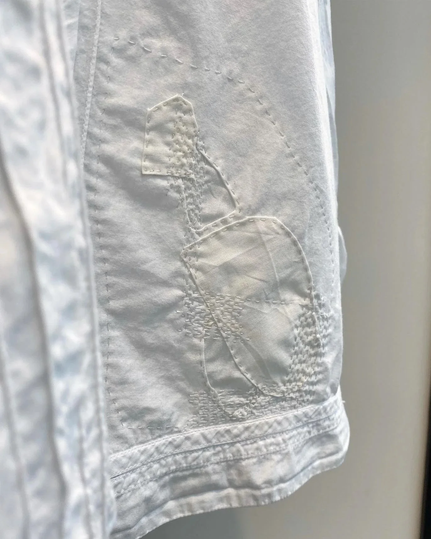 Close up detail of discreet patch repairs and sashiko in matching fabric and thread