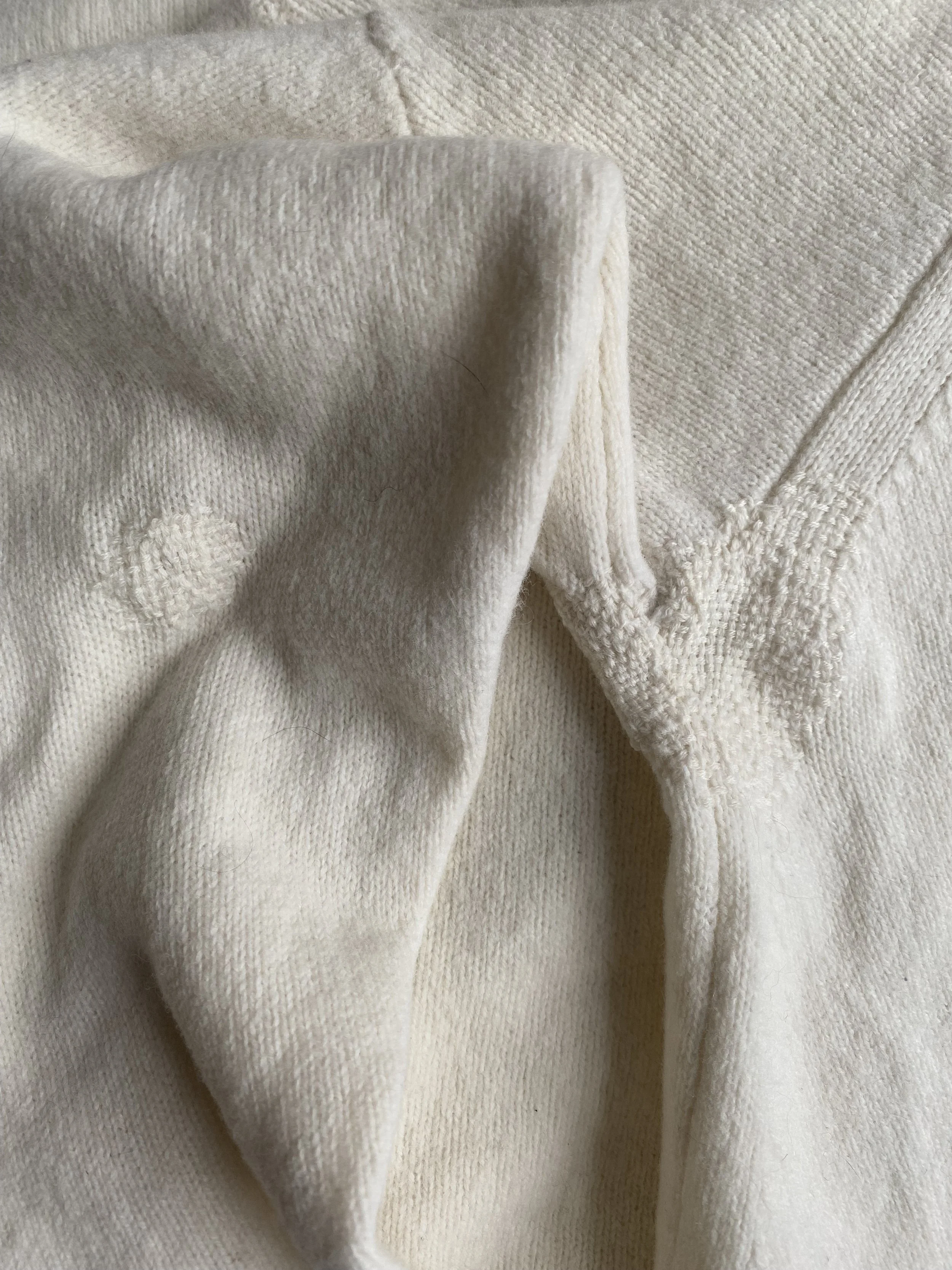 Invisible repair, discreet darning on cream knitted jumper