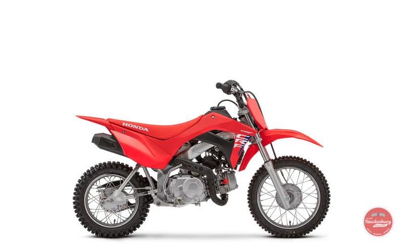 Red Honda dirt bike with knobby tires, black seat, and front suspension, positioned sideways on a black background.