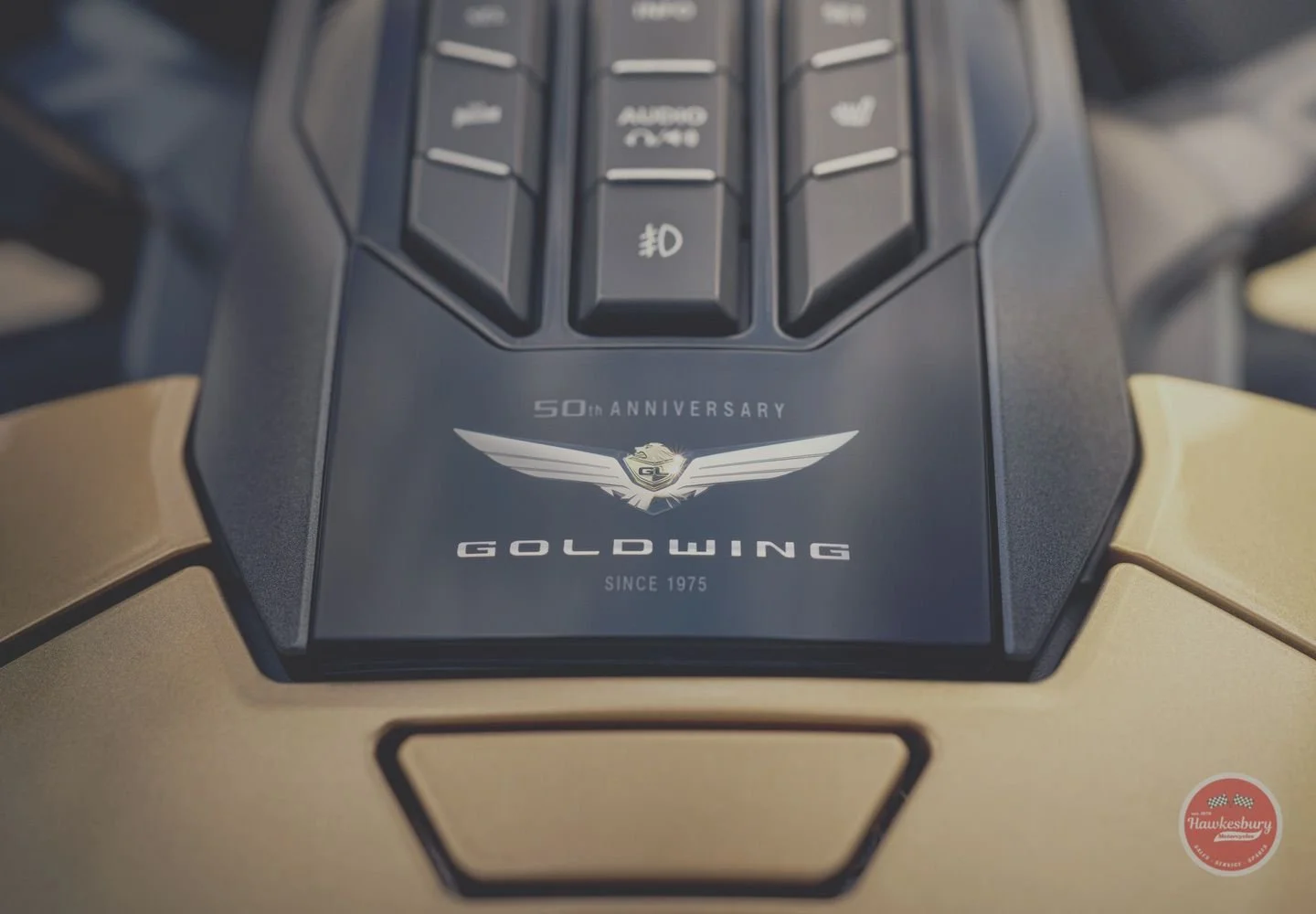 Close-up of a Lamborghini car interior display with Goldwing 50th anniversary logo, winged emblem, and Goldwing text, with a small Hawkesbury logo in the bottom right corner.