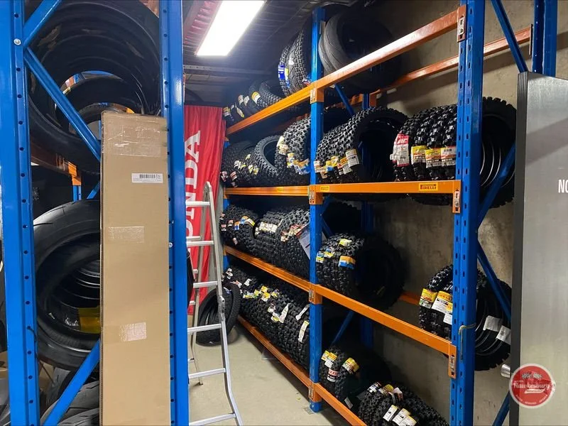 Shelves stocked with stacks of tires in a warehouse.