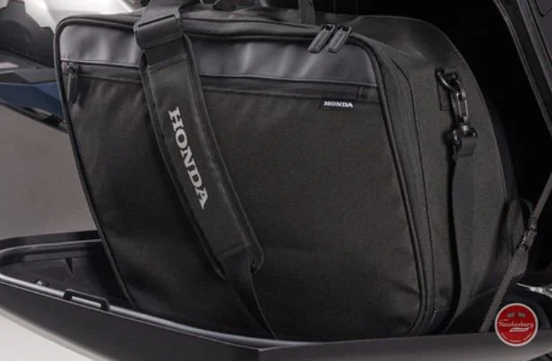 Black Honda-branded motorcycle or scooter bag in a compartment.